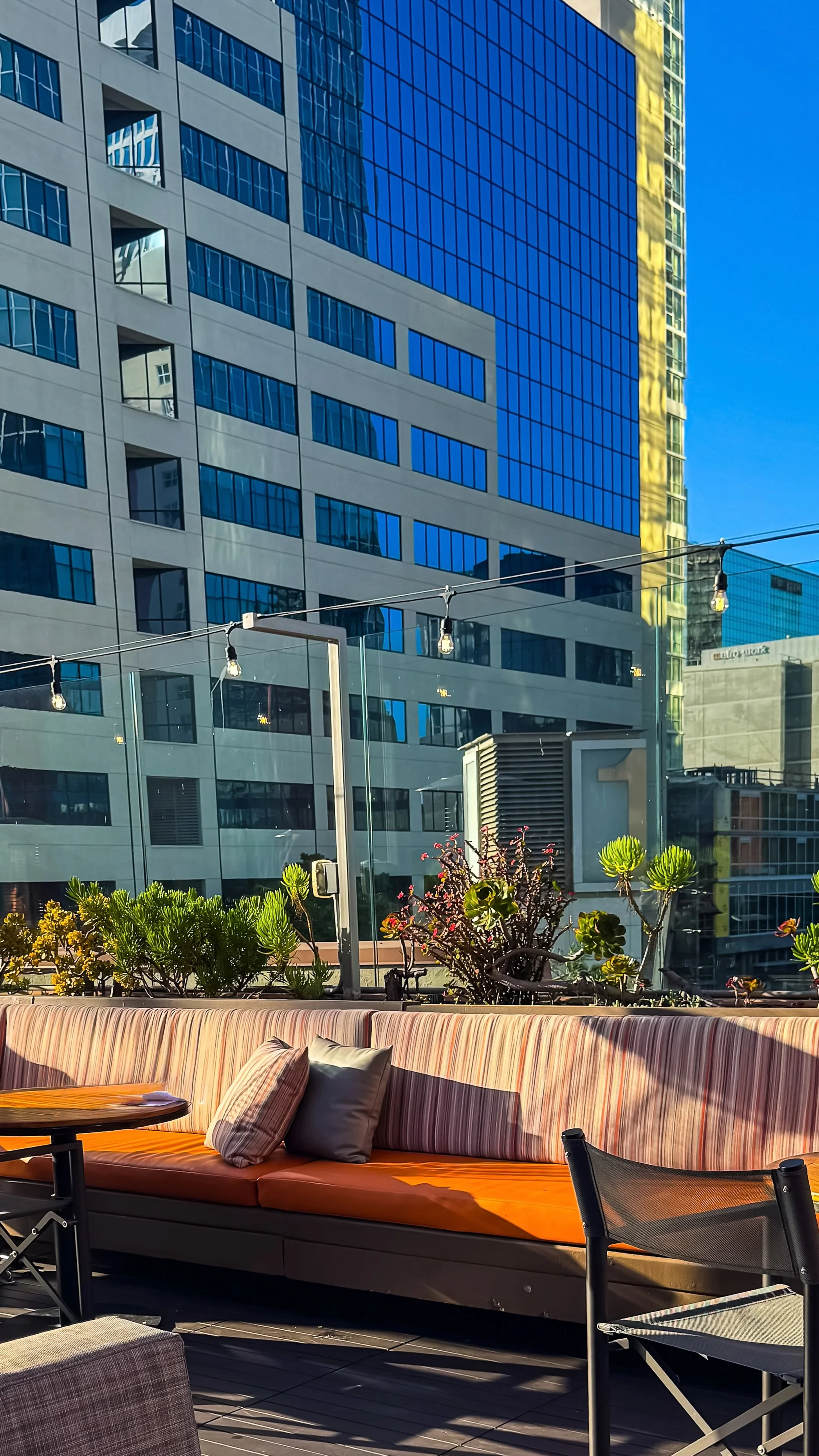 Modern rooftop lounge overlooking San Diego’s skyline with stylish outdoor seating and relaxed ambiance