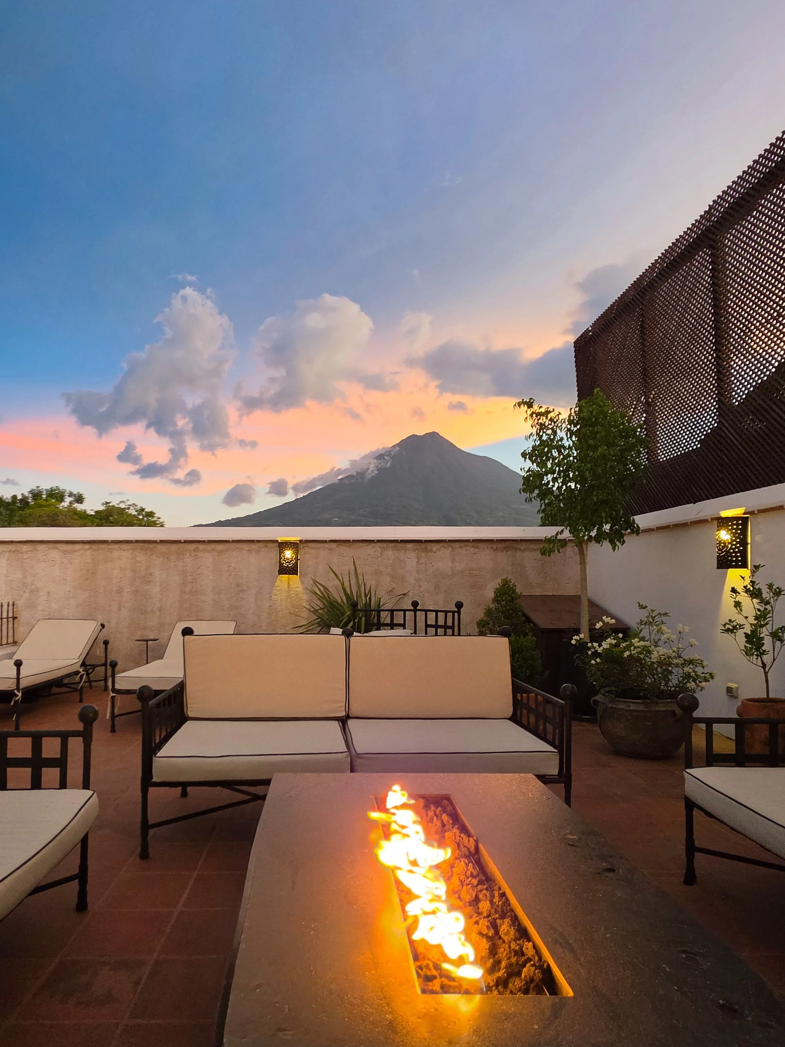 Rooftop terrace with fire pit and panoramic views of Volcán de Agua at sunset
