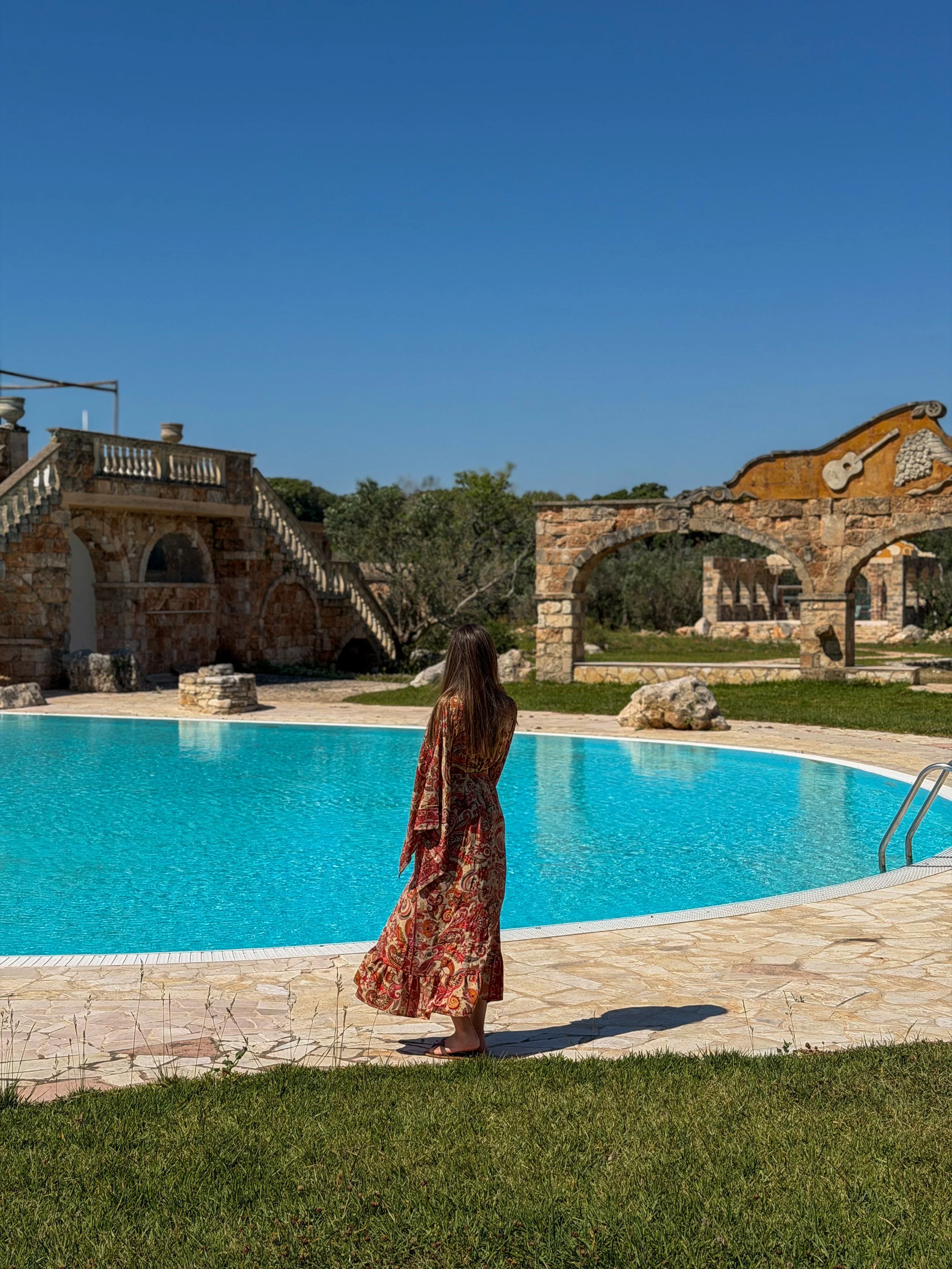 Relaxing poolside atmosphere surrounded by historic stone architecture and expansive grounds at Tenute Al Bano