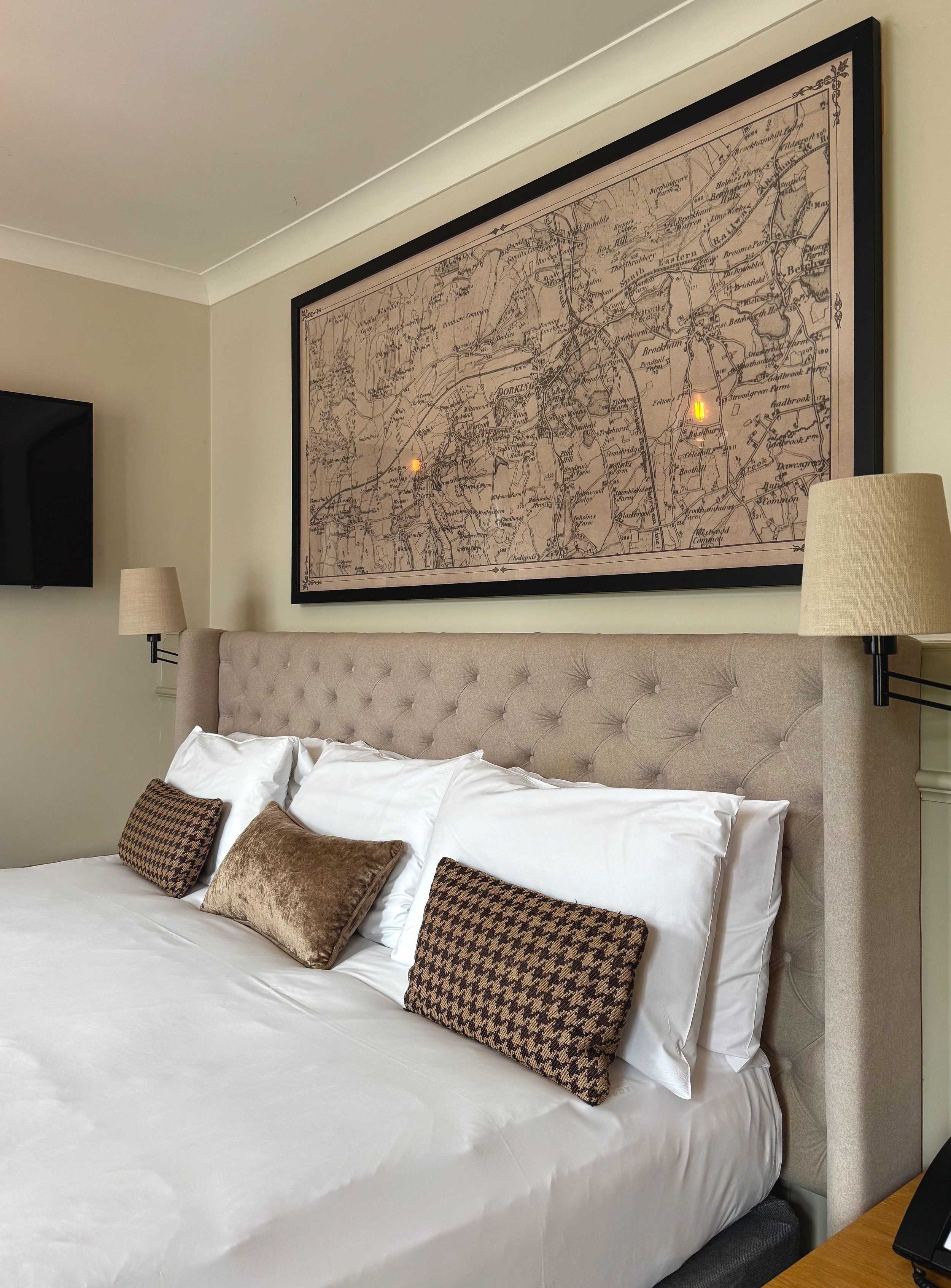 Elegant guest bedroom featuring bespoke map artwork and classic country house interiors