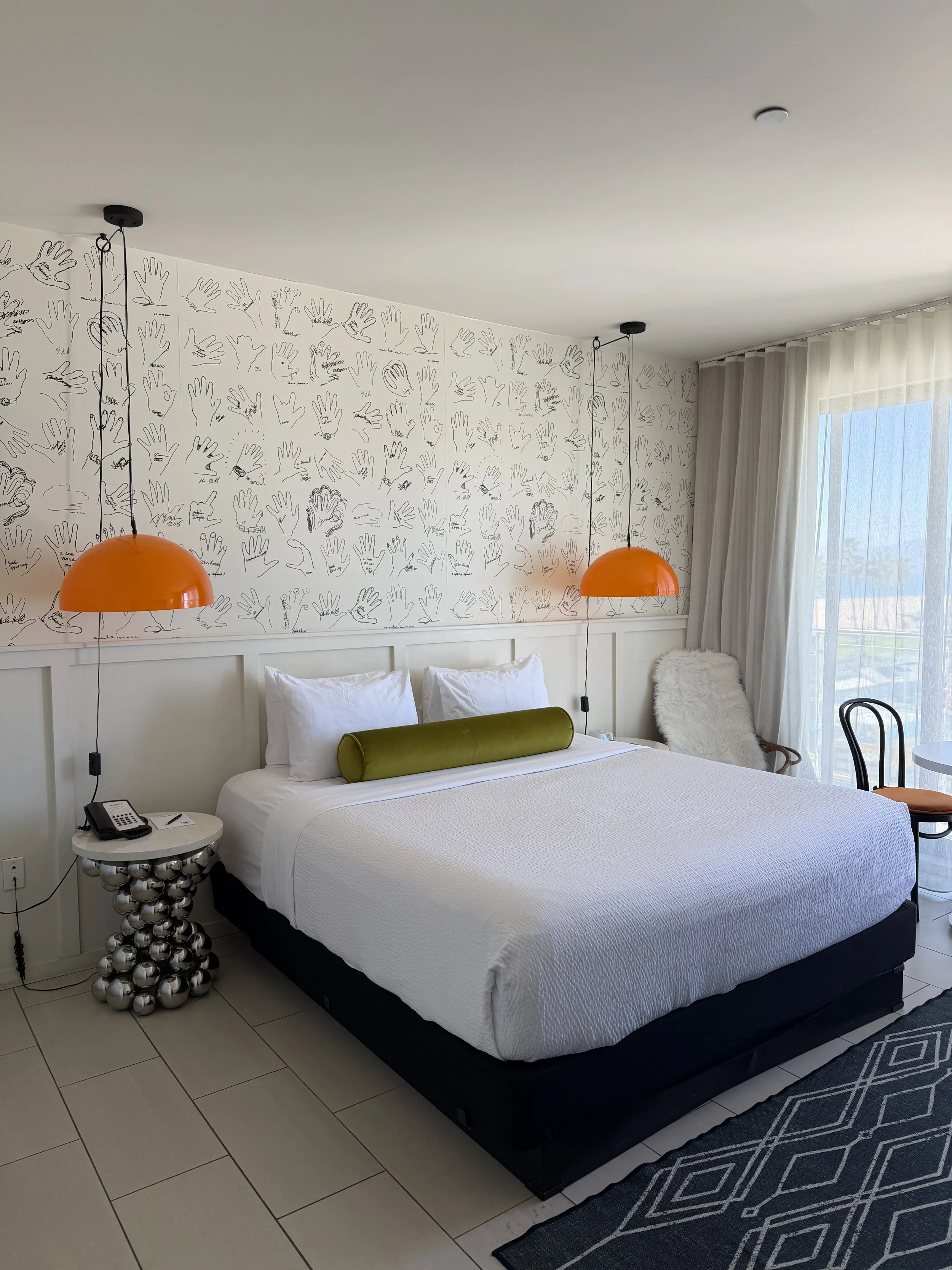 Contemporary guest room with artistic wallpaper, vibrant accents, and modern California-inspired design