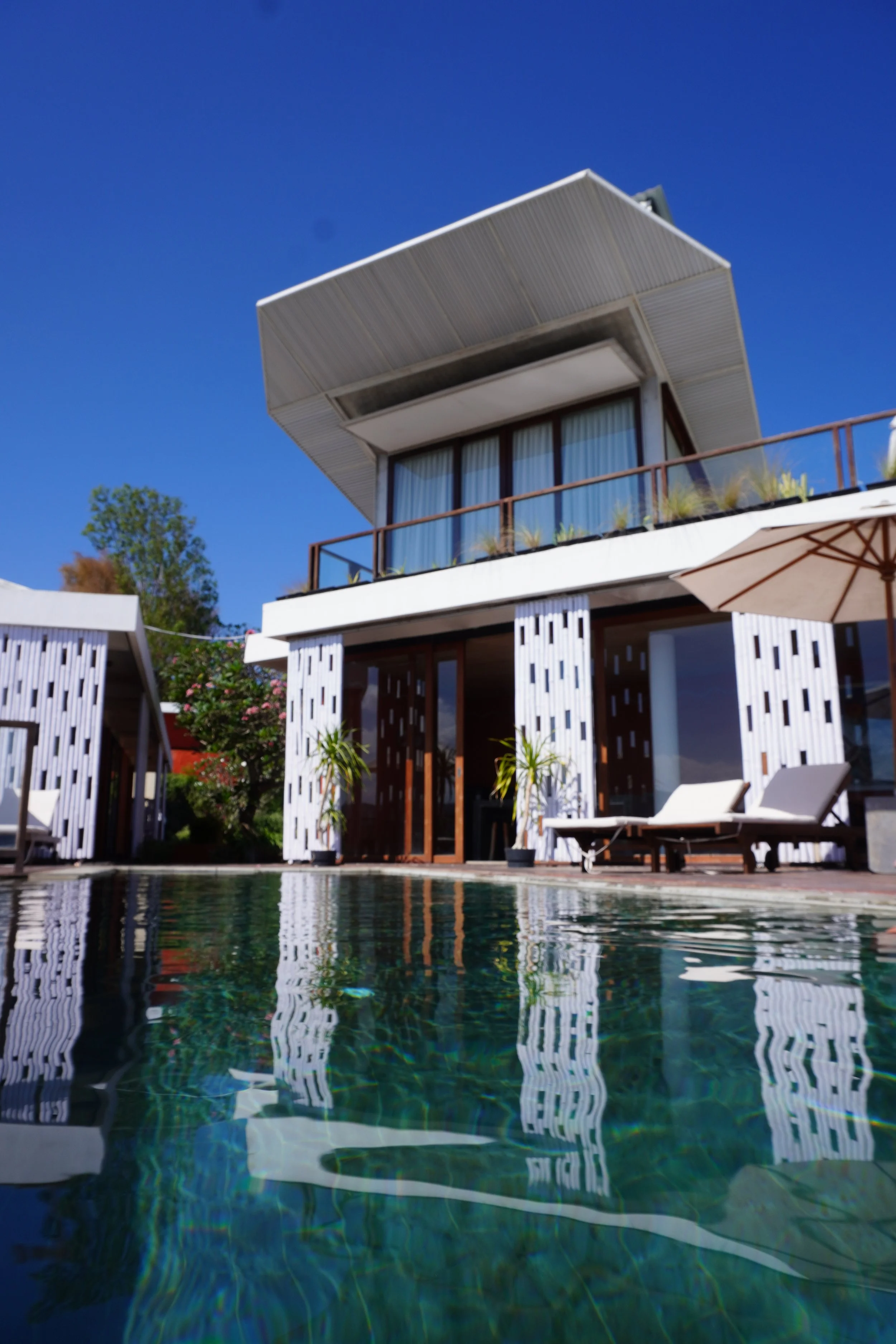 Contemporary villa exterior reflected in a crystal clear swimming pool