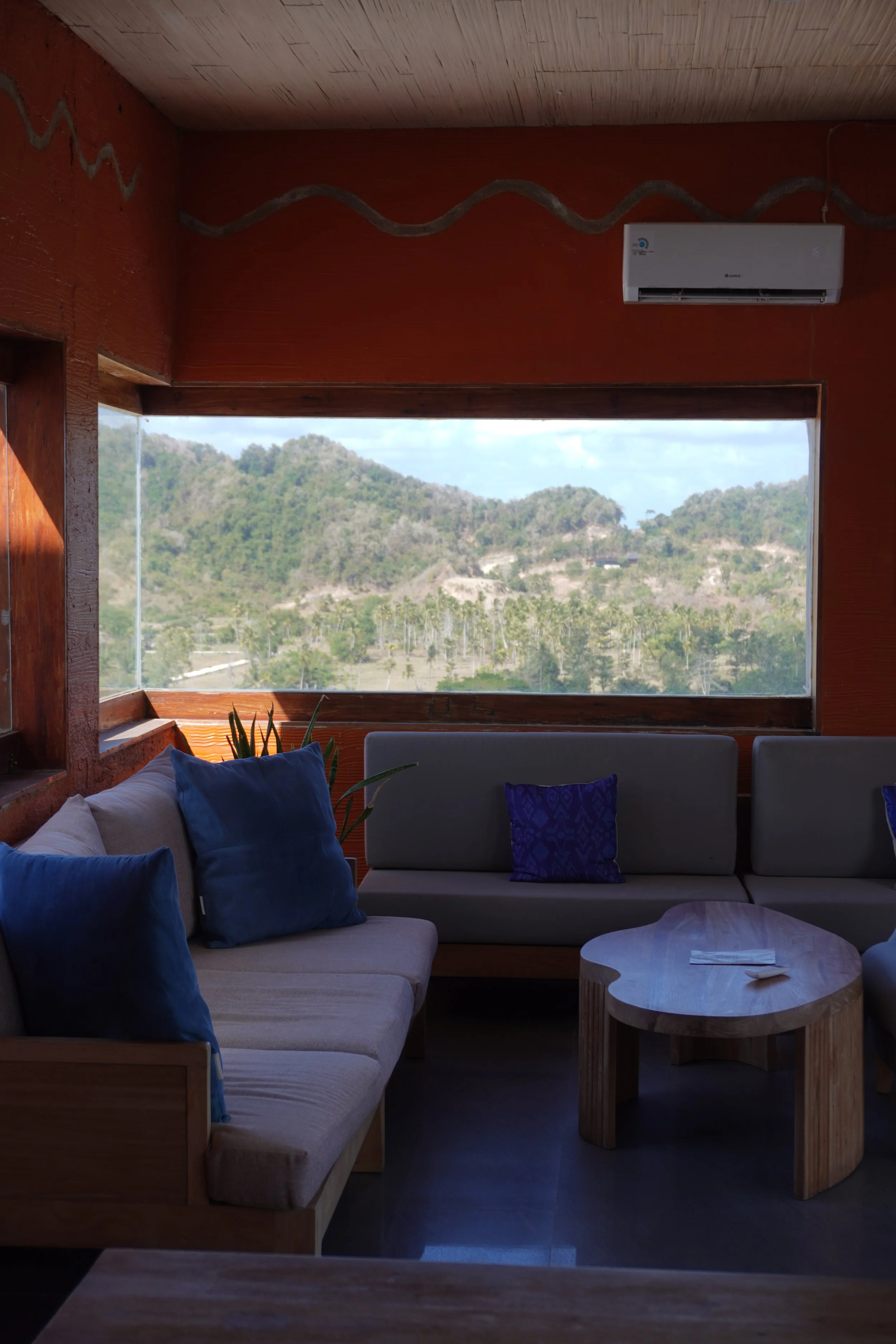 Spacious lounge overlooking Lombok's lush hills through panoramic windows