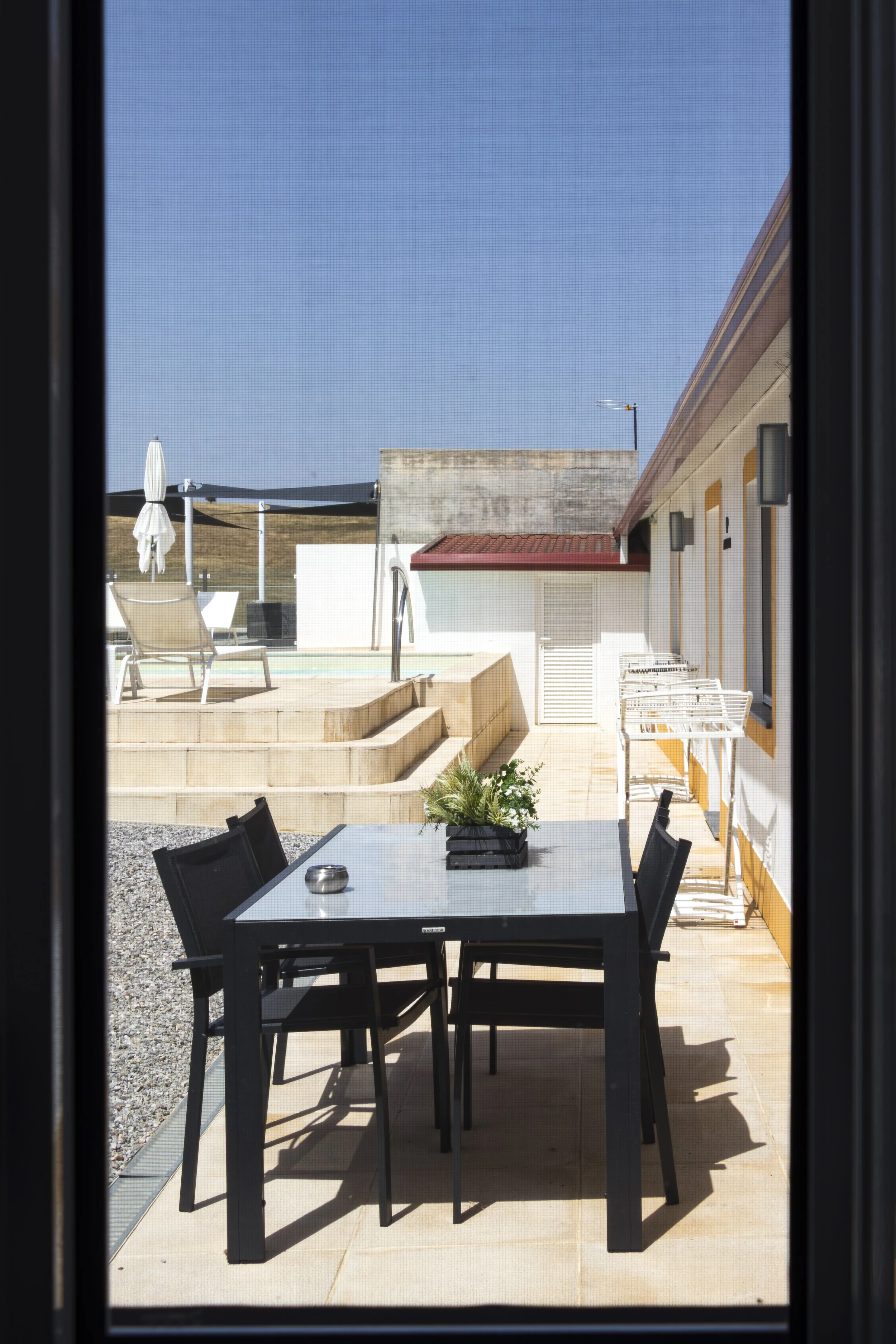 Private outdoor terrace overlooking the swimming pool with dining area and countryside views