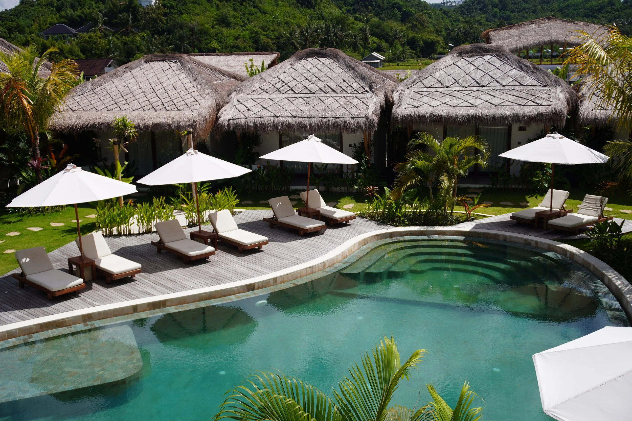 Boutique villas overlooking a tranquil lagoon-style pool in a tropical setting