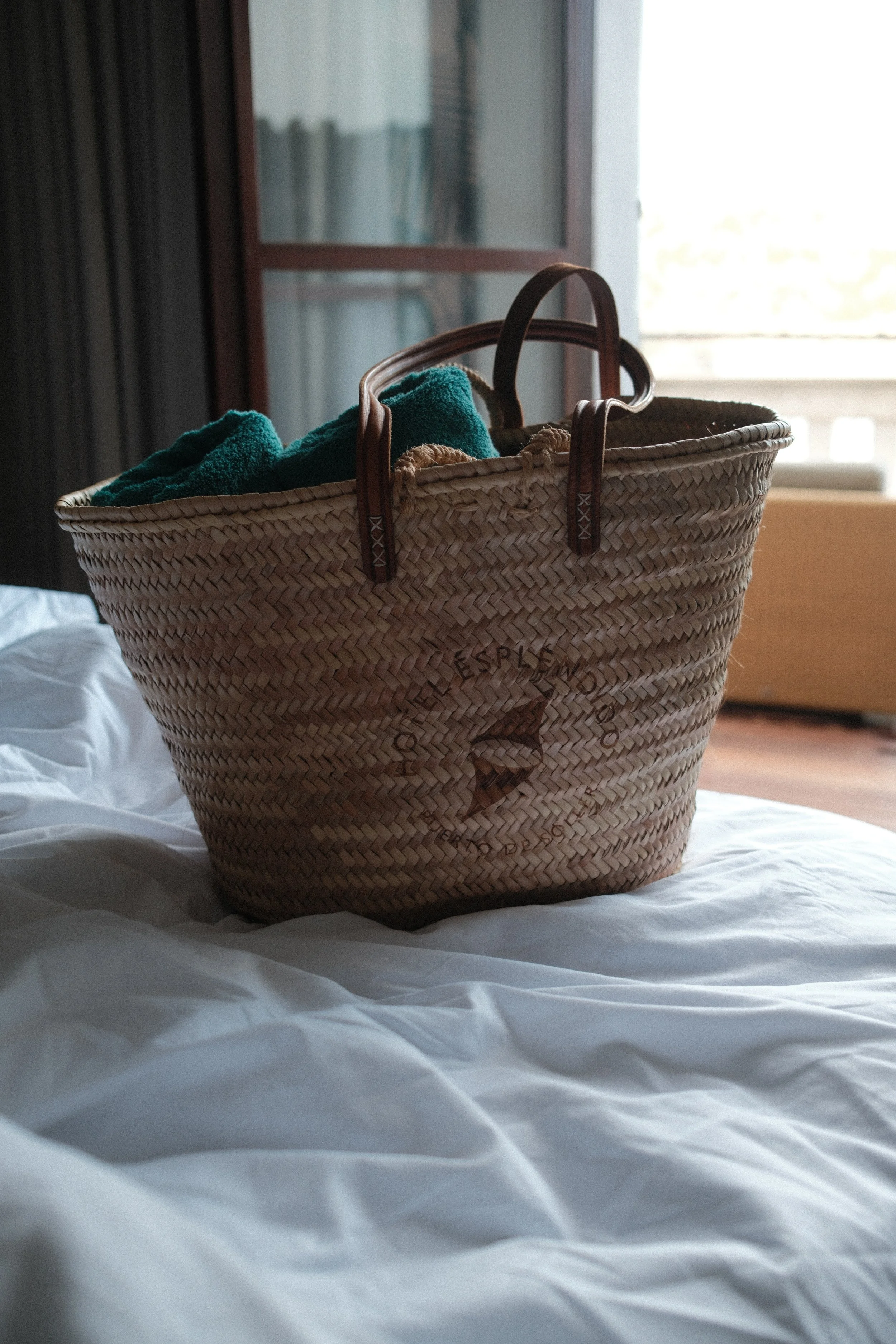 Woven beach bag styled inside a guest room at Hotel Espléndido