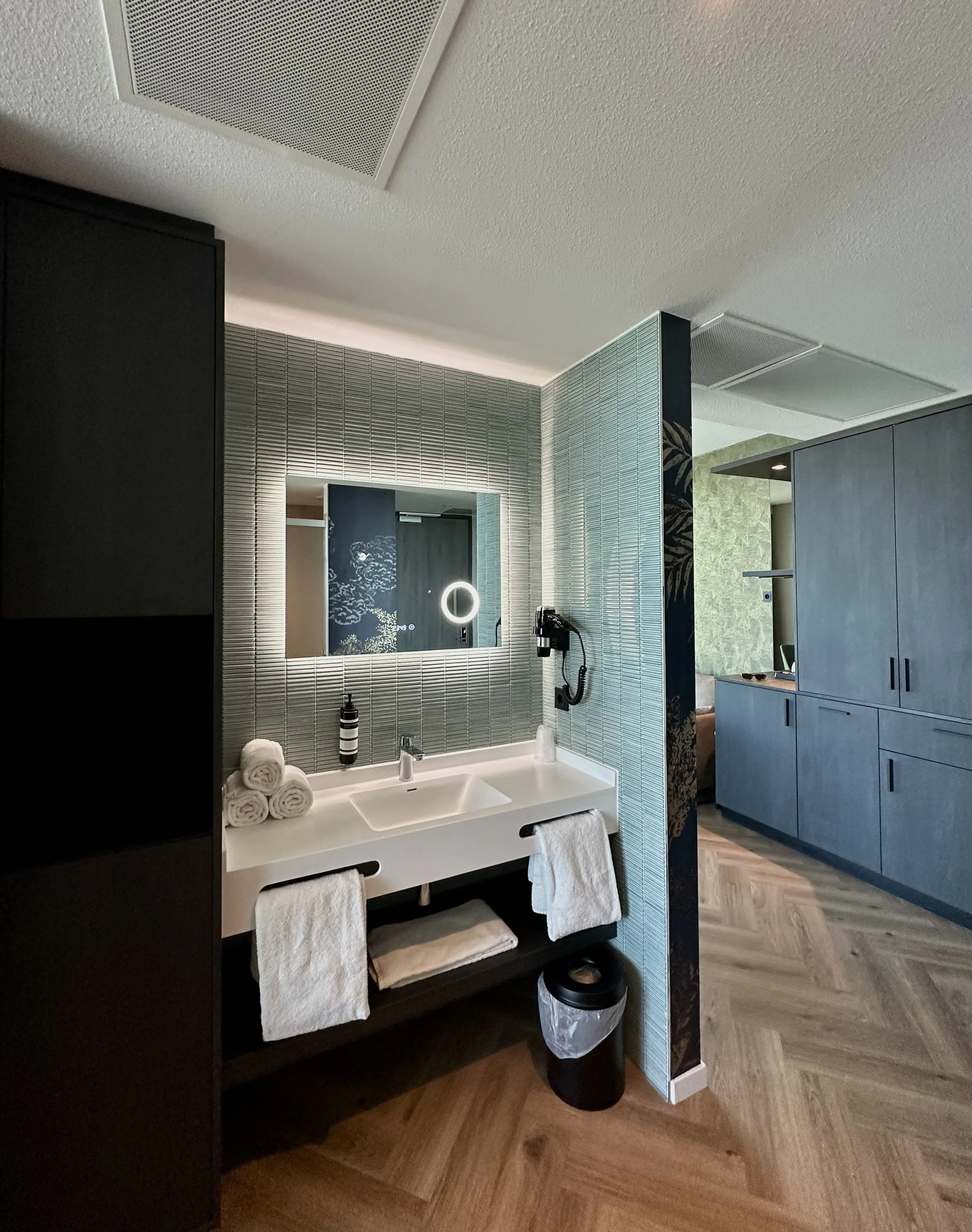 Contemporary open-plan bathroom with illuminated mirror and stylish finishes