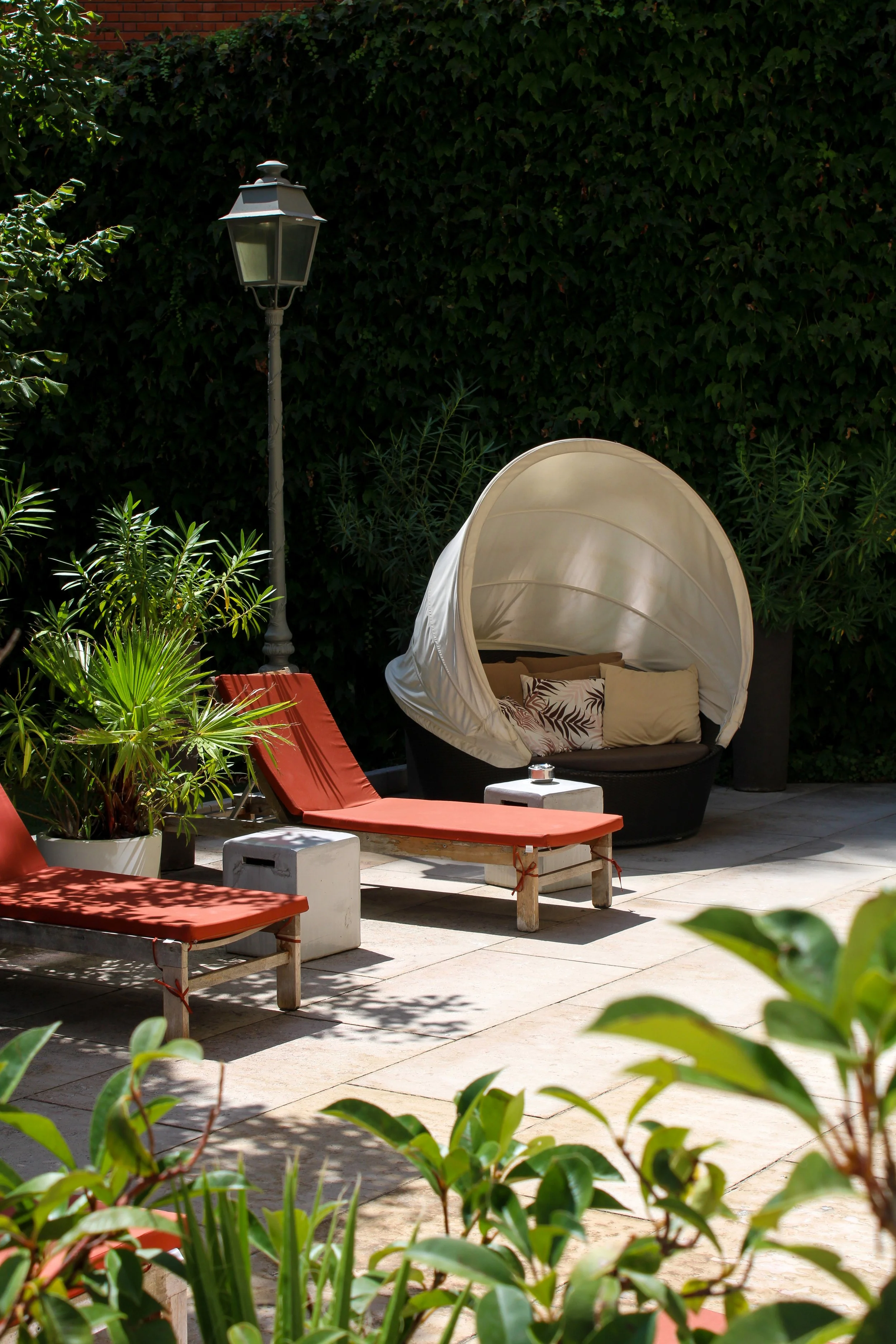 Peaceful garden solarium with loungers surrounded by lush greenery