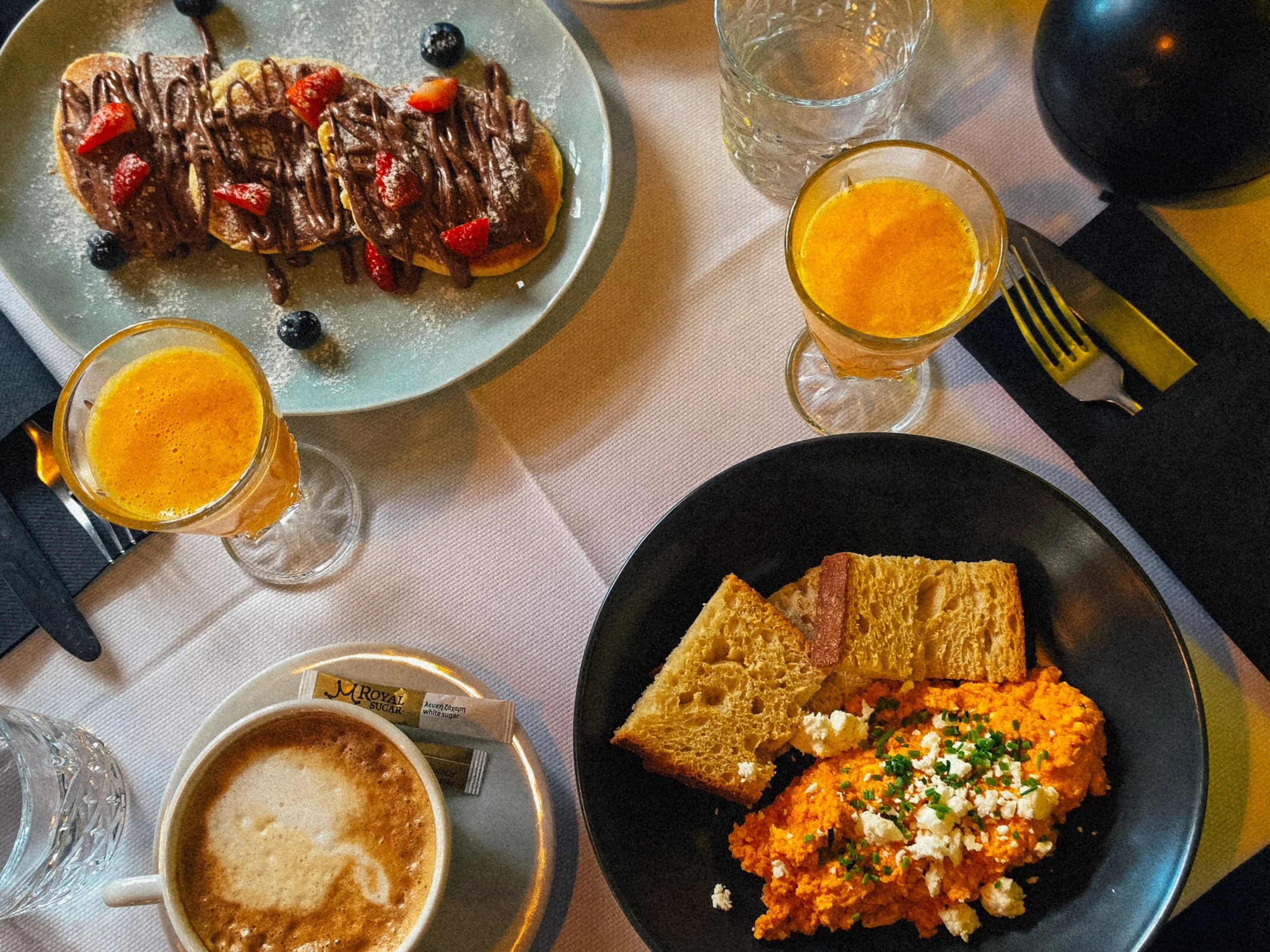 Stylish breakfast spread with coffee, fresh juice, pancakes, and Greek specialties at She Mykonos Hotel