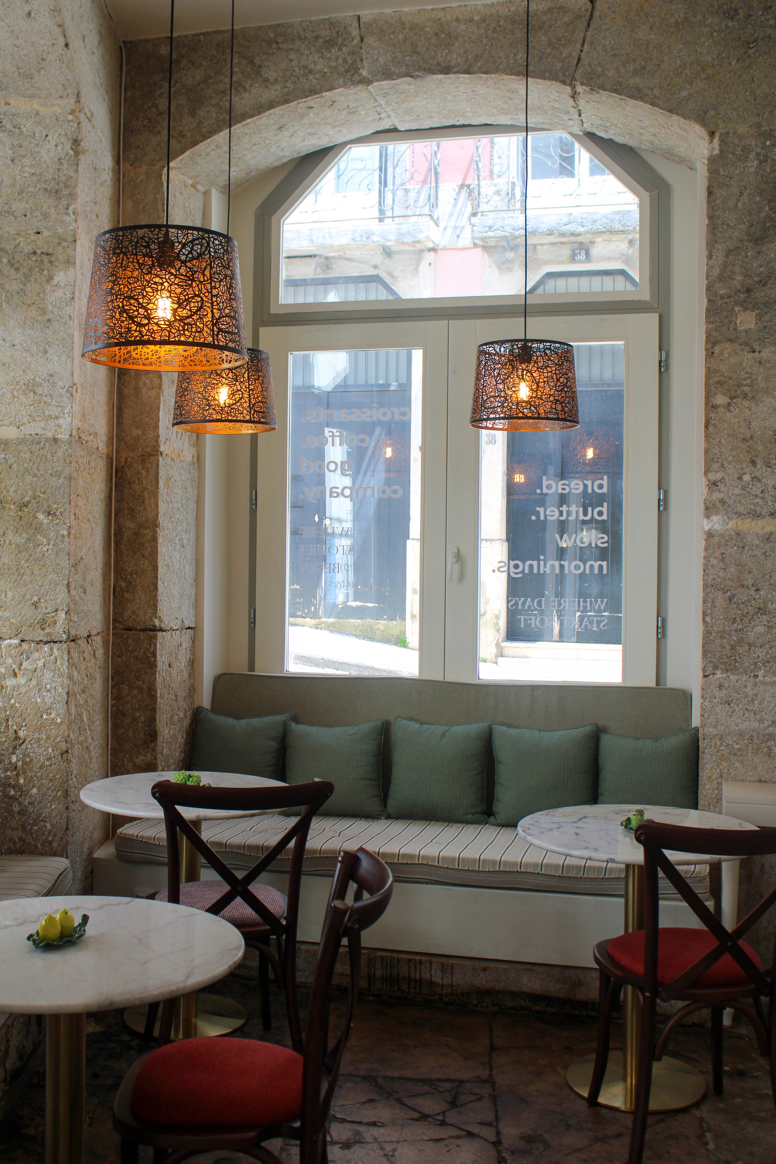 Charming café seating area blending historic stone architecture with contemporary comfort at Once Upon Lisboa