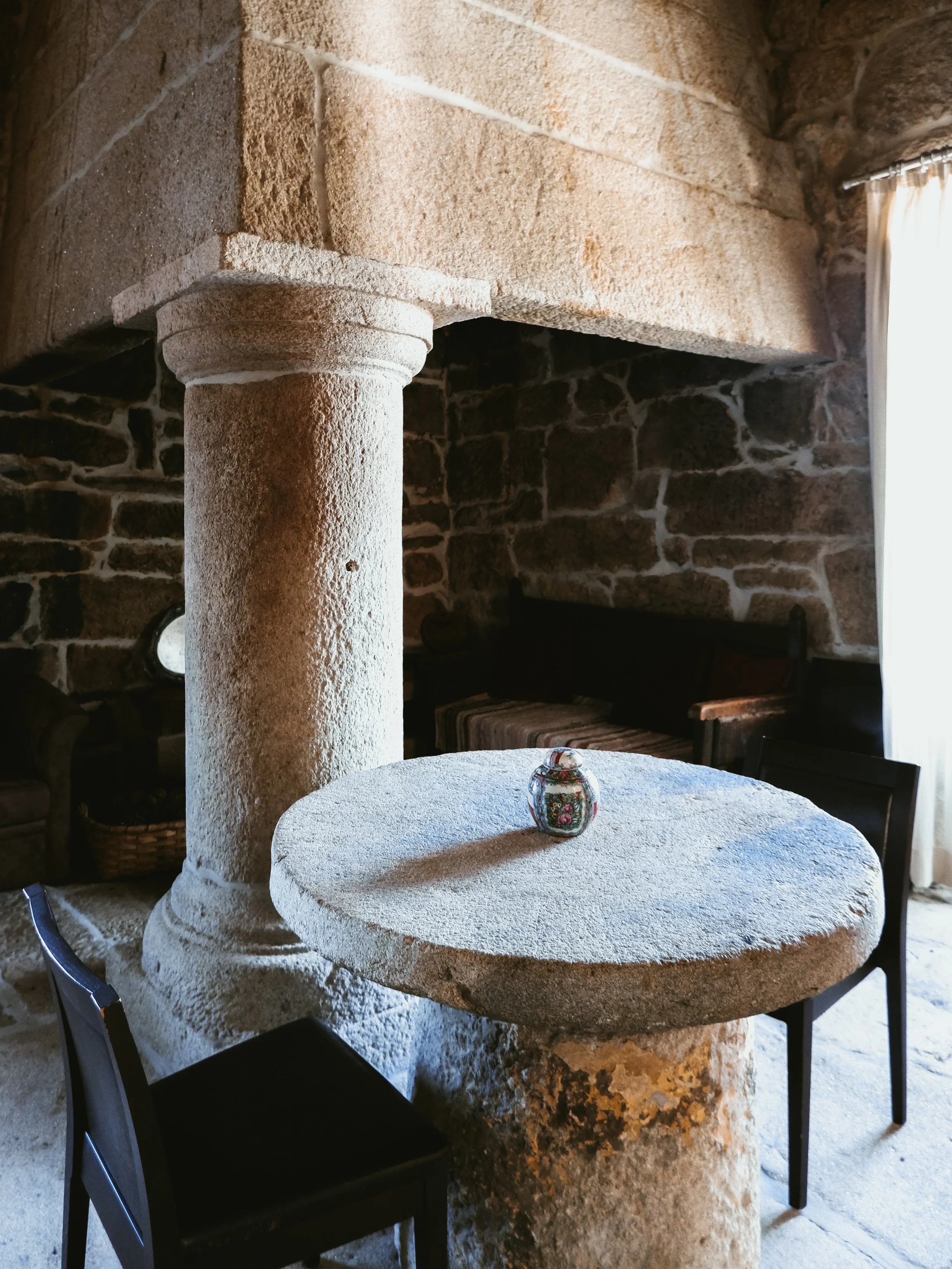 Rustic stone interior with traditional column and round table, showcasing authentic regional architecture and heritage design, Casas Novas Countryside Hotel Spa & Events – Chaves, Portugal.