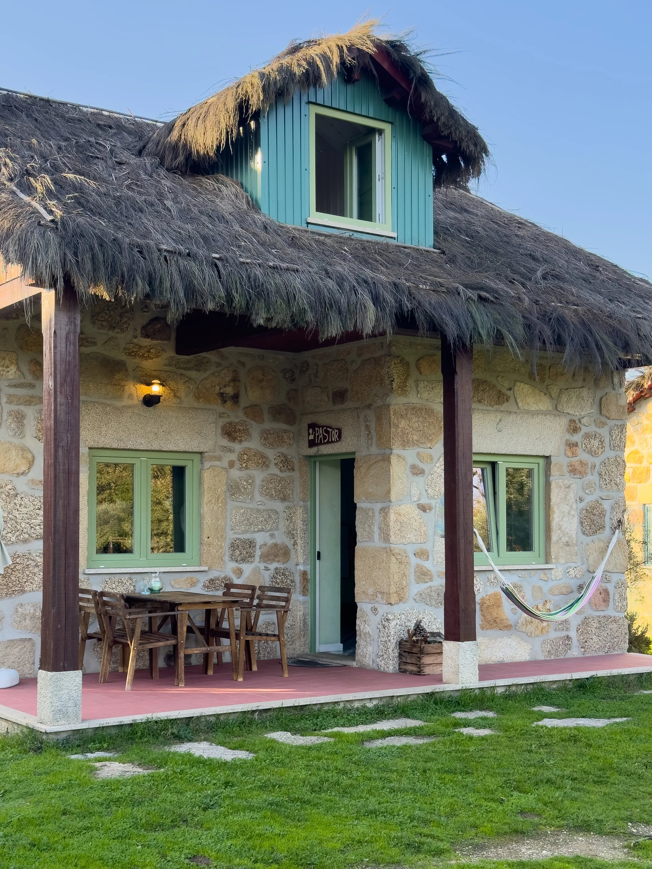 Traditional granite cottage with thatched roof, private terrace, and hammock at Chão do Rio