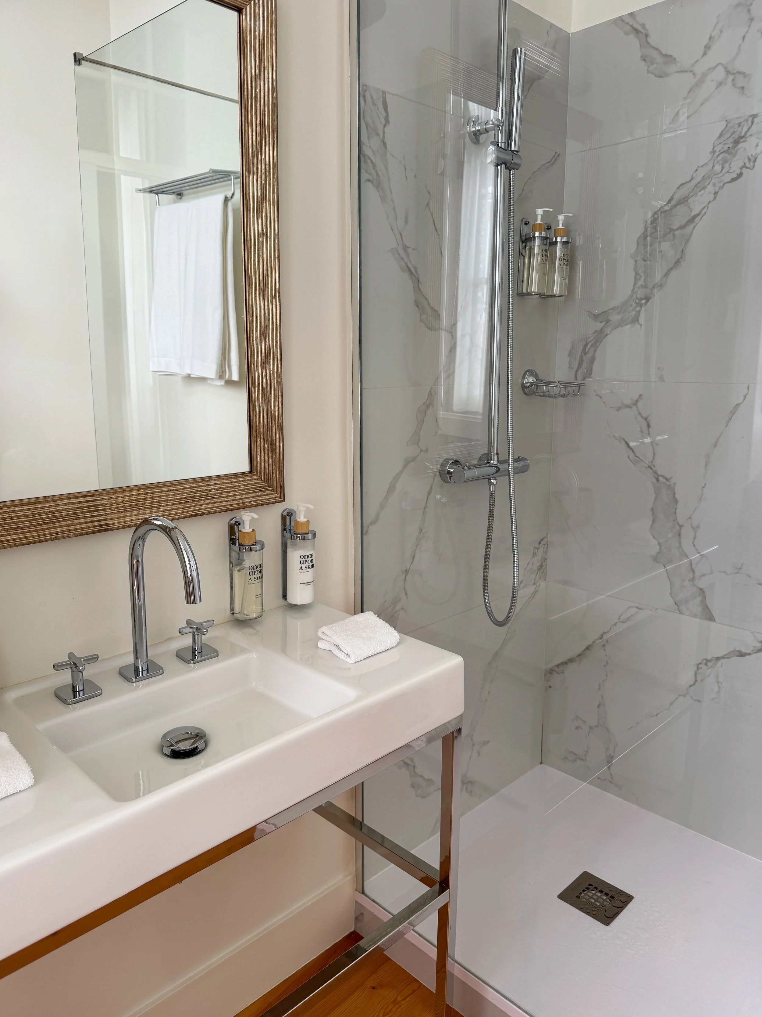 Elegant marble bathroom with walk in rainfall shower and premium amenities at Once Upon Lisboa, Lisbon, Portugal