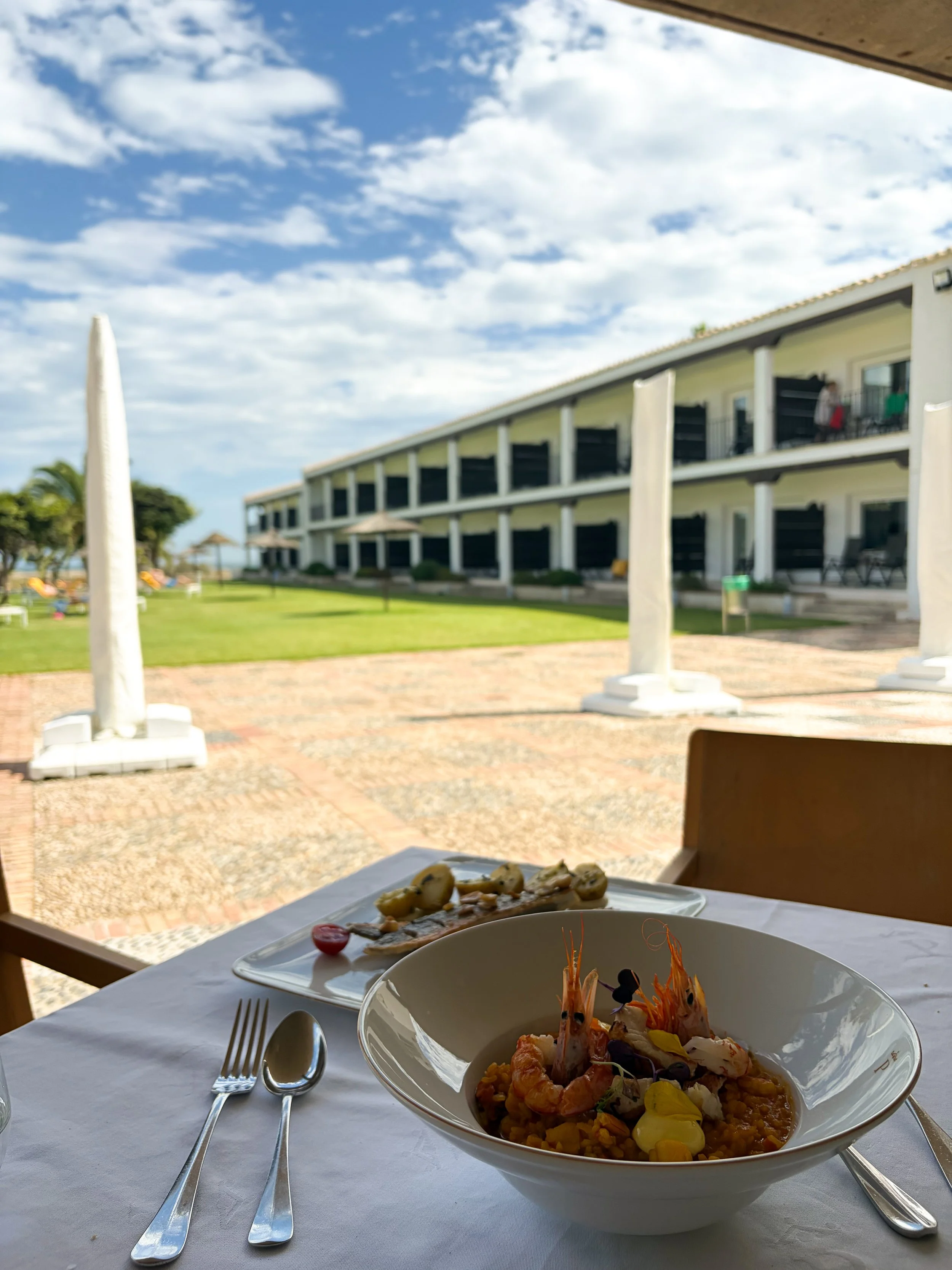 Mediterranean seafood dish served beside the landscaped resort gardens