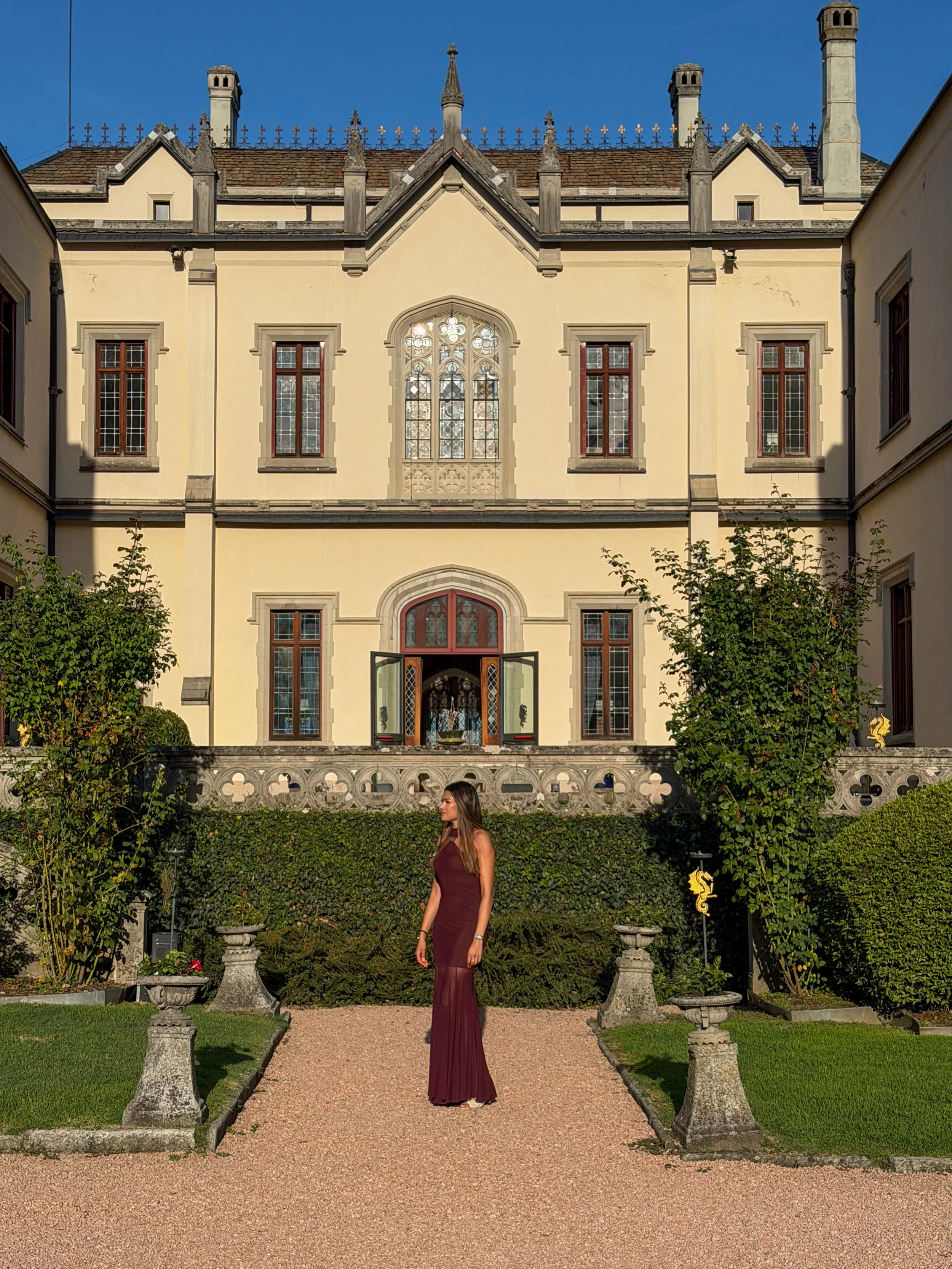 The castle's magnificent Neo-Gothic façade framed by formal Italian gardens