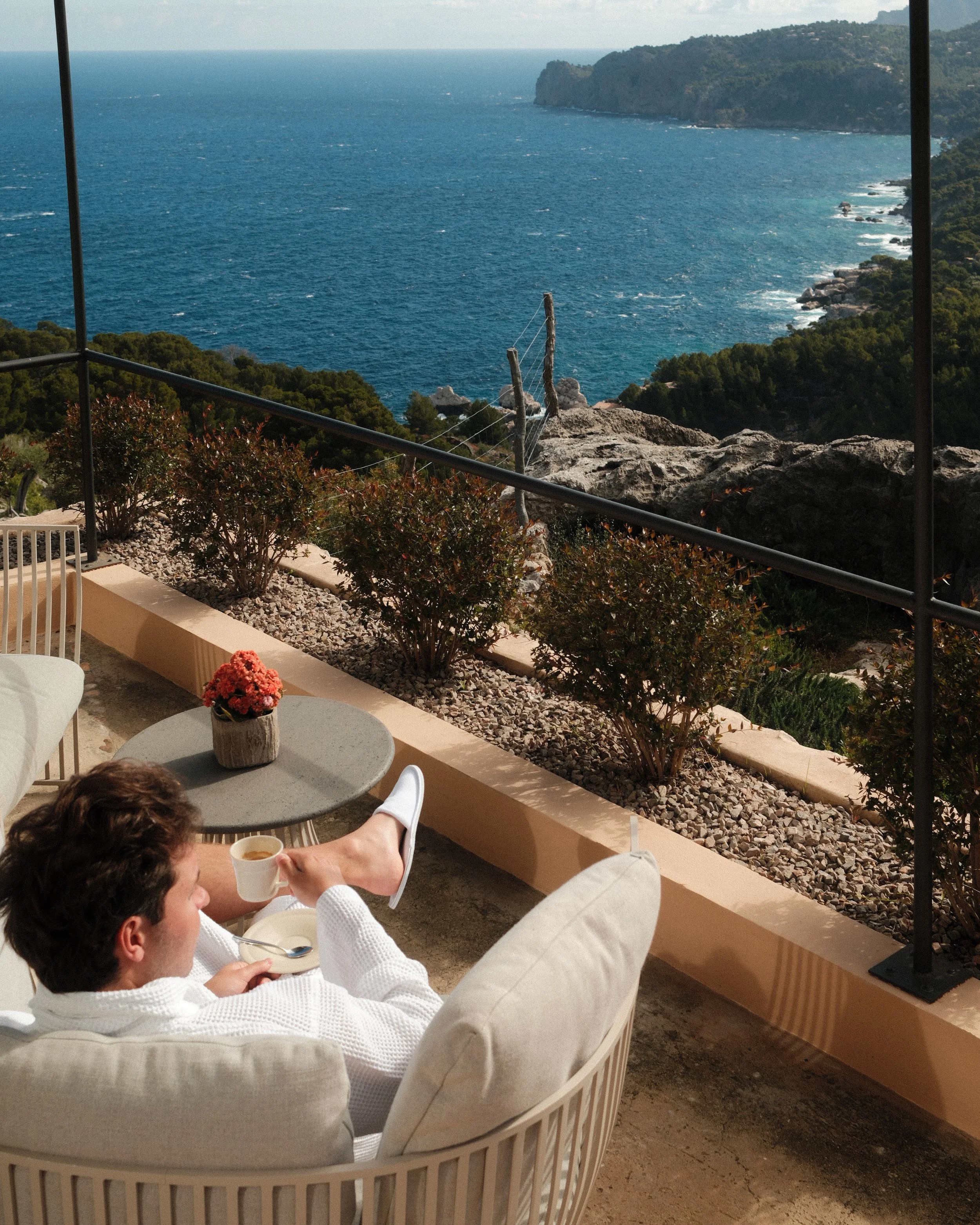 Guest enjoying morning coffee on a private terrace overlooking the Mediterranean Sea at Sa Pedrissa, Deià, Mallorca