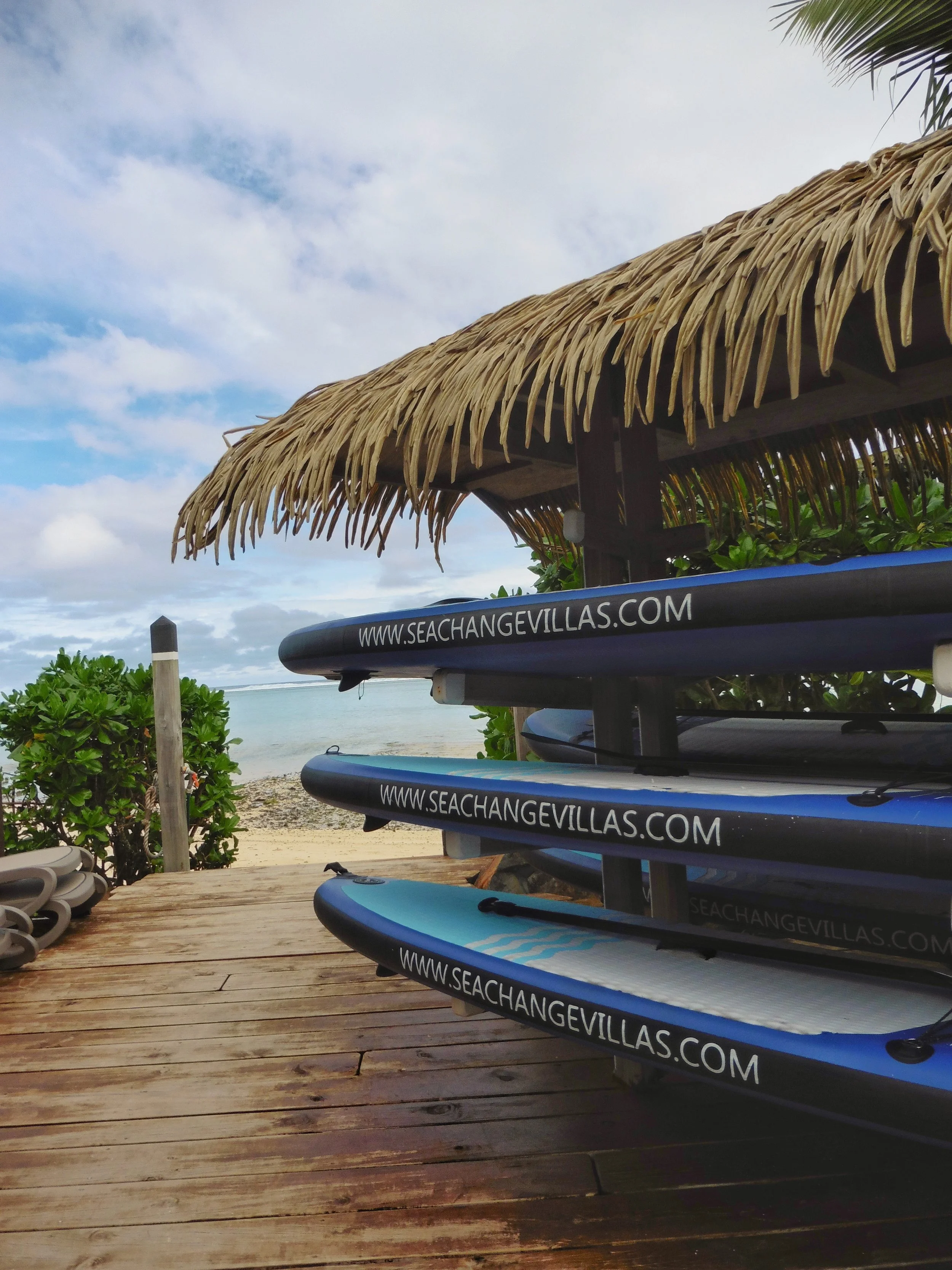 Paddleboards by the beach at Sea Change Villas overlooking the lagoon in Rarotonga, Cook Islands