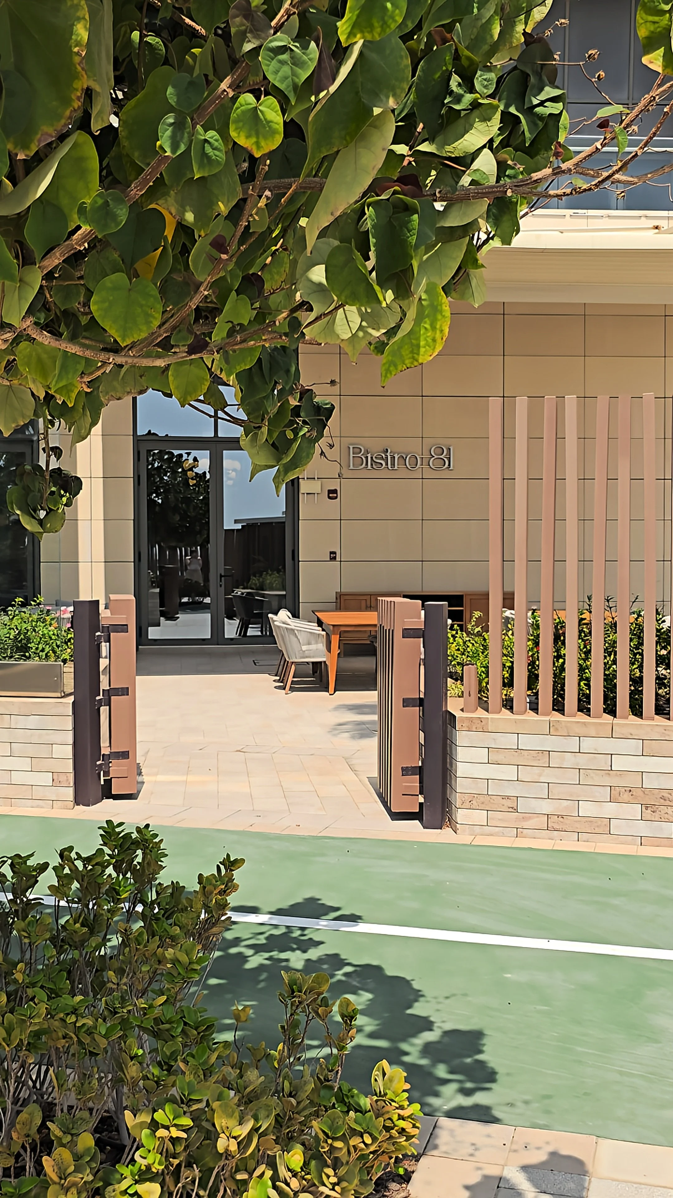 Bistro 81 restaurant entrance featuring an outdoor dining terrace, contemporary architecture, and surrounding greenery