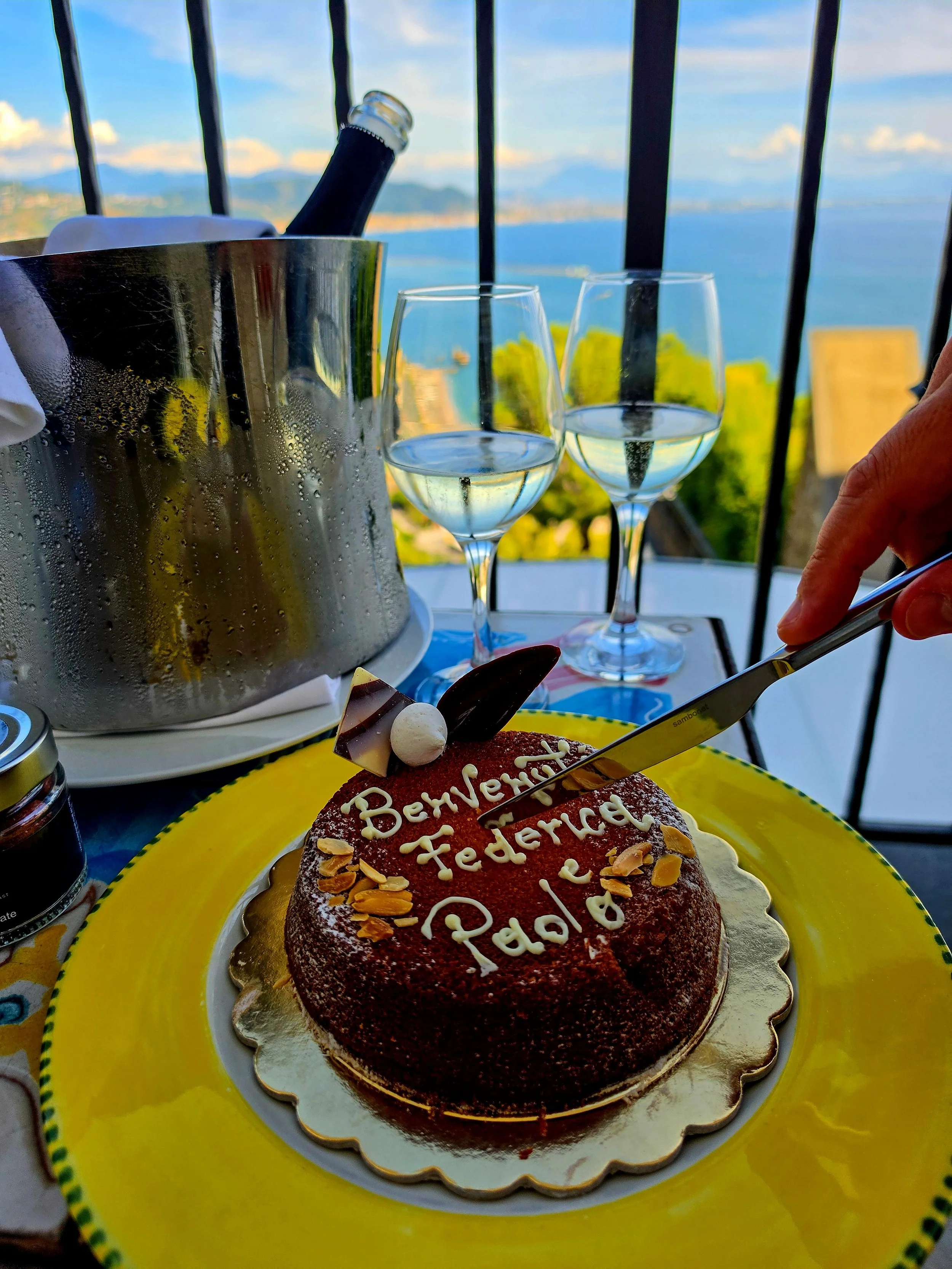 Welcome cake and sparkling wine served on a terrace with panoramic sea views