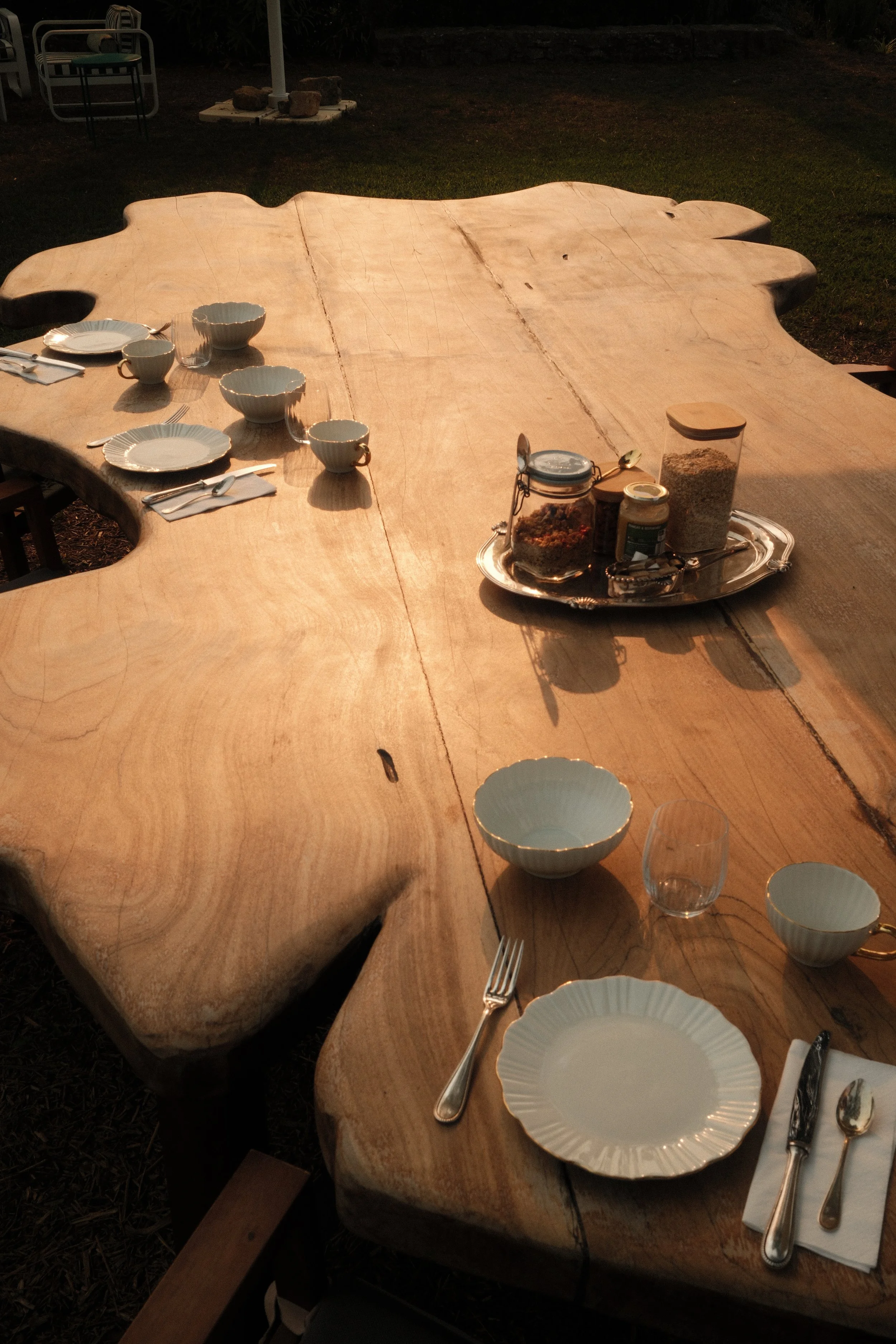 Communal breakfast table crafted from natural wood in the garden sunshine