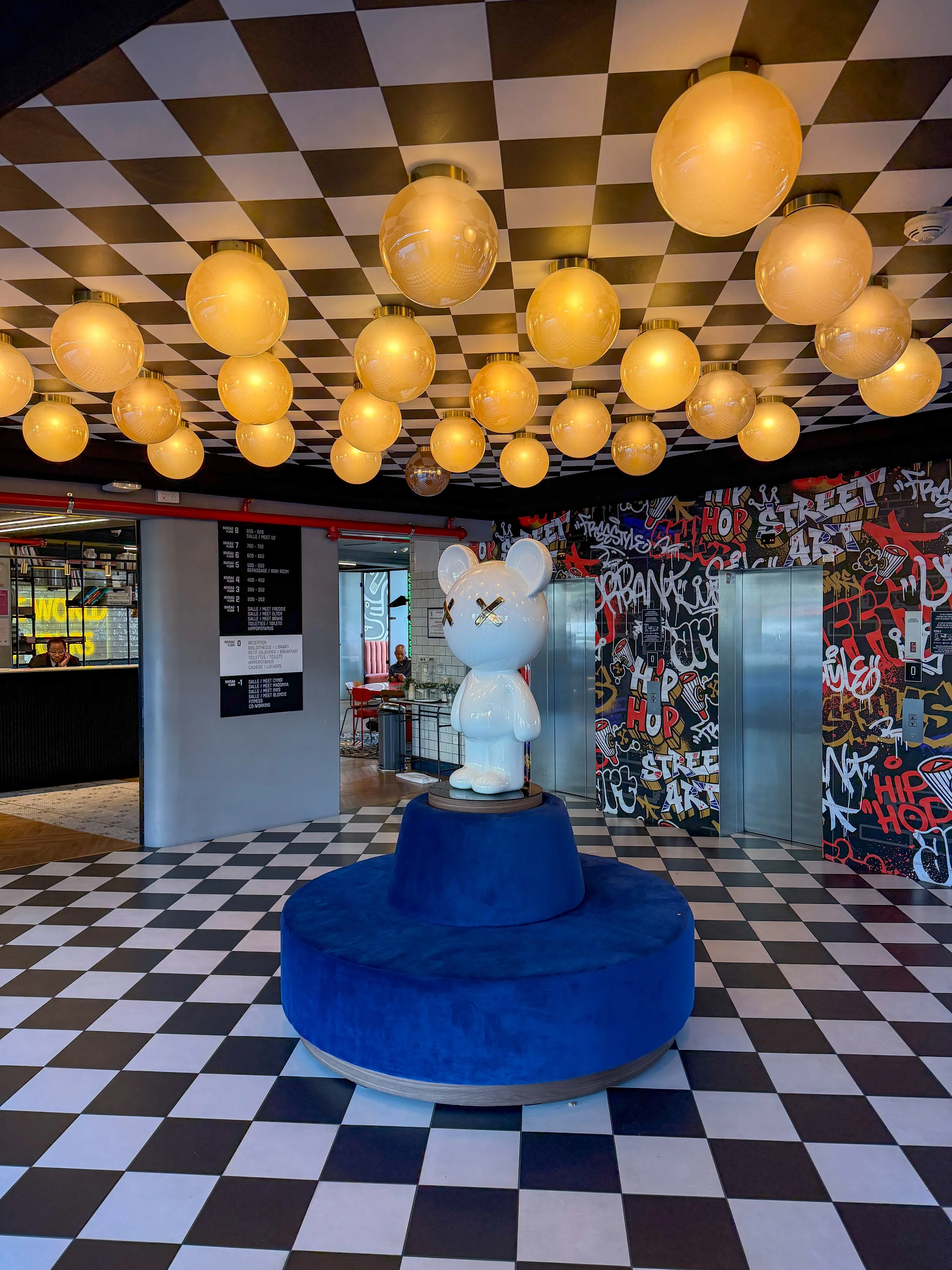 Checkerboard lobby featuring designer lighting, street art, and playful contemporary décor