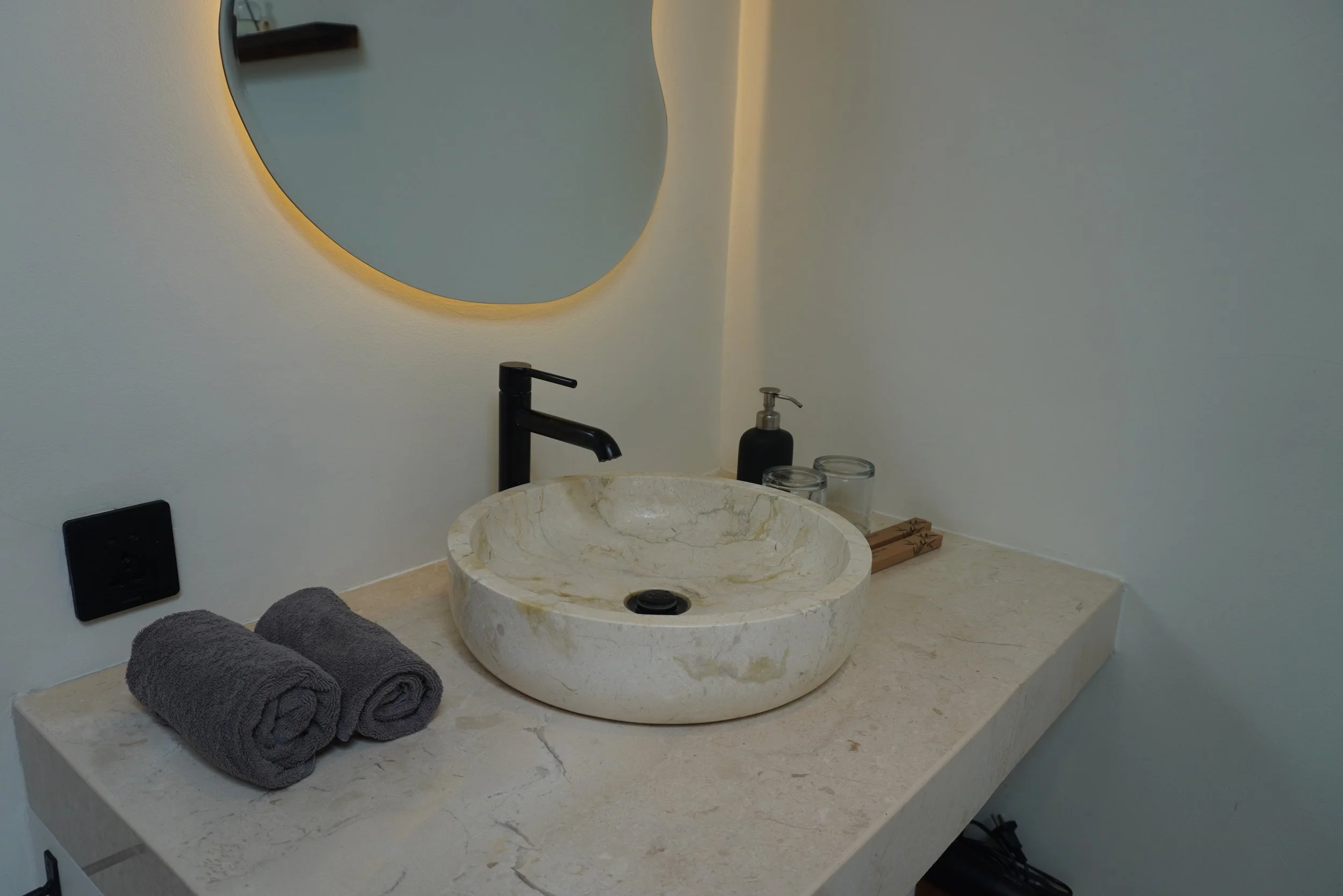 Modern stone vanity with handcrafted basin and minimalist bathroom design