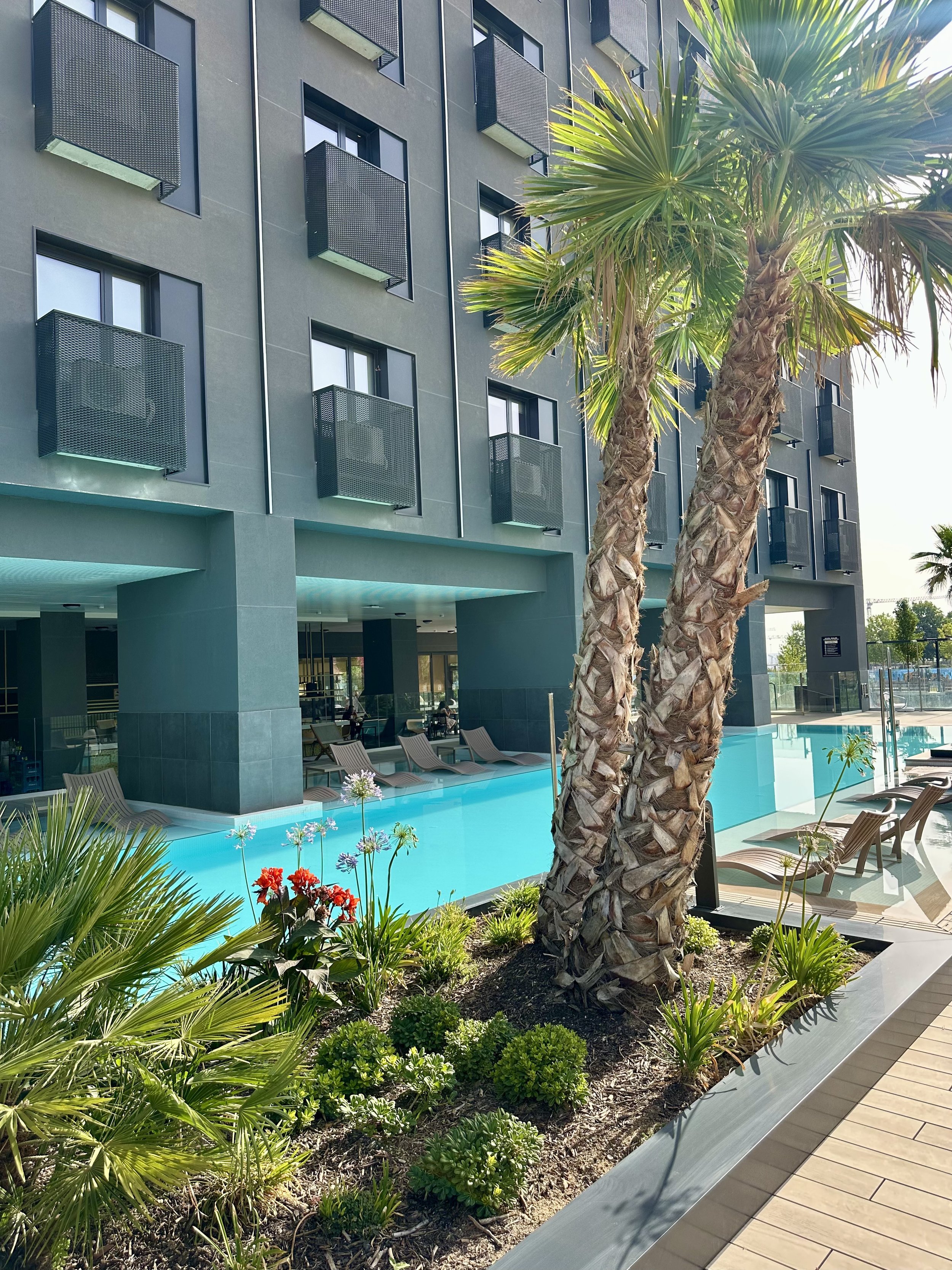 Contemporary hotel exterior with landscaped pool area and modern architecture