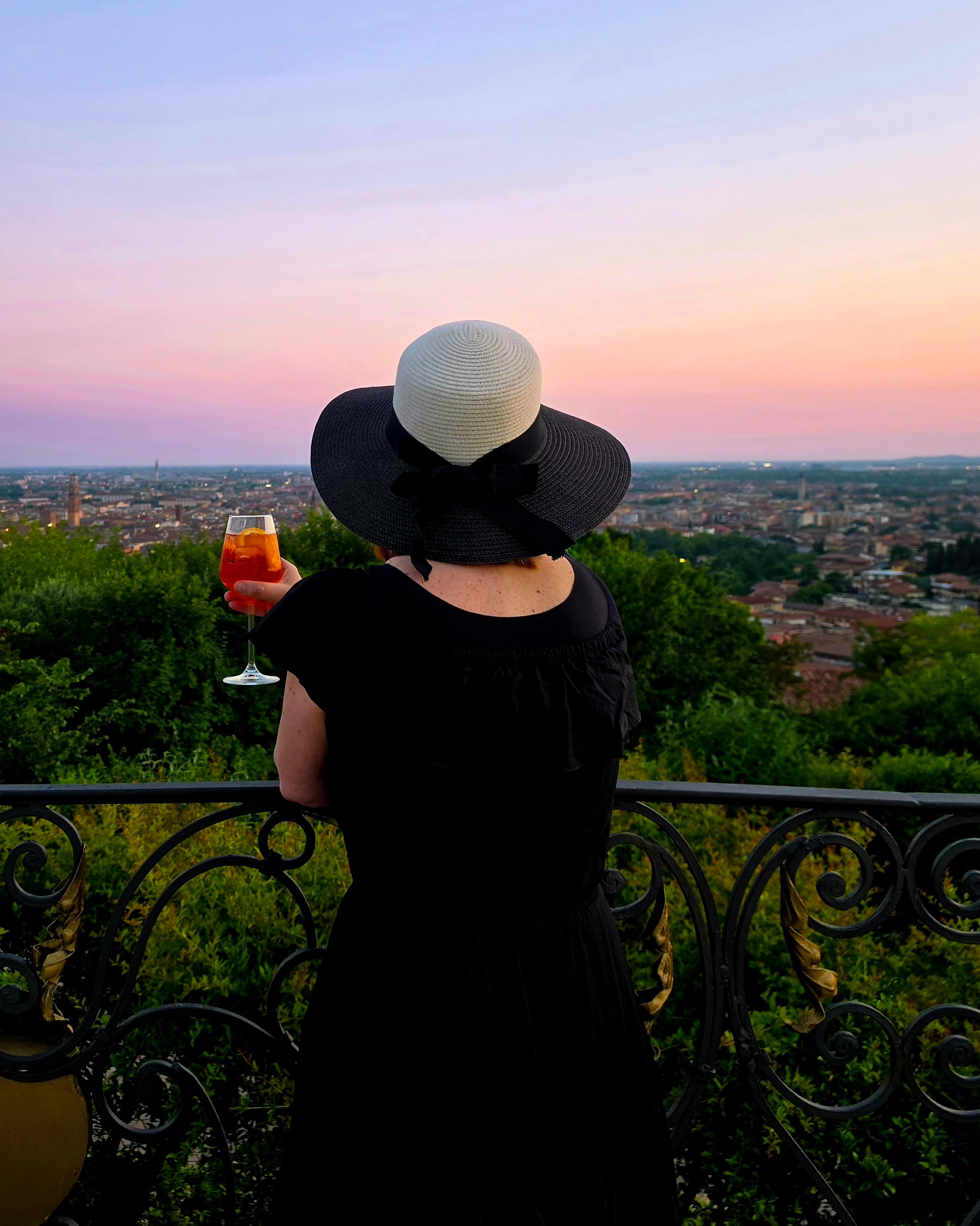 Guest watching the sunset from the gardens of Relais Fra’ Lorenzo while enjoying an aperitivo