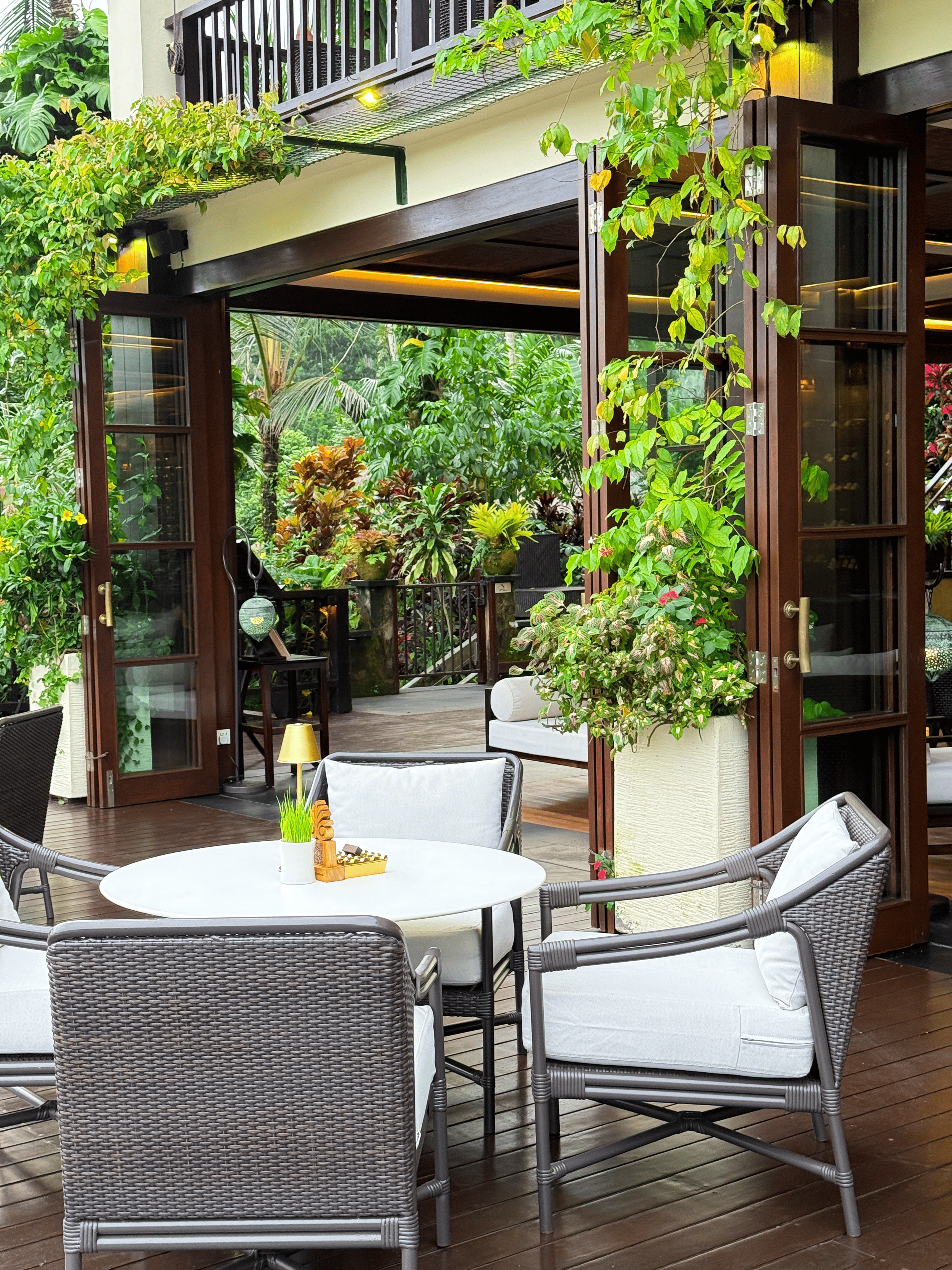 An open-air dining terrace surrounded by tropical greenery provides an elegant setting for breakfast, lunch, and dinner