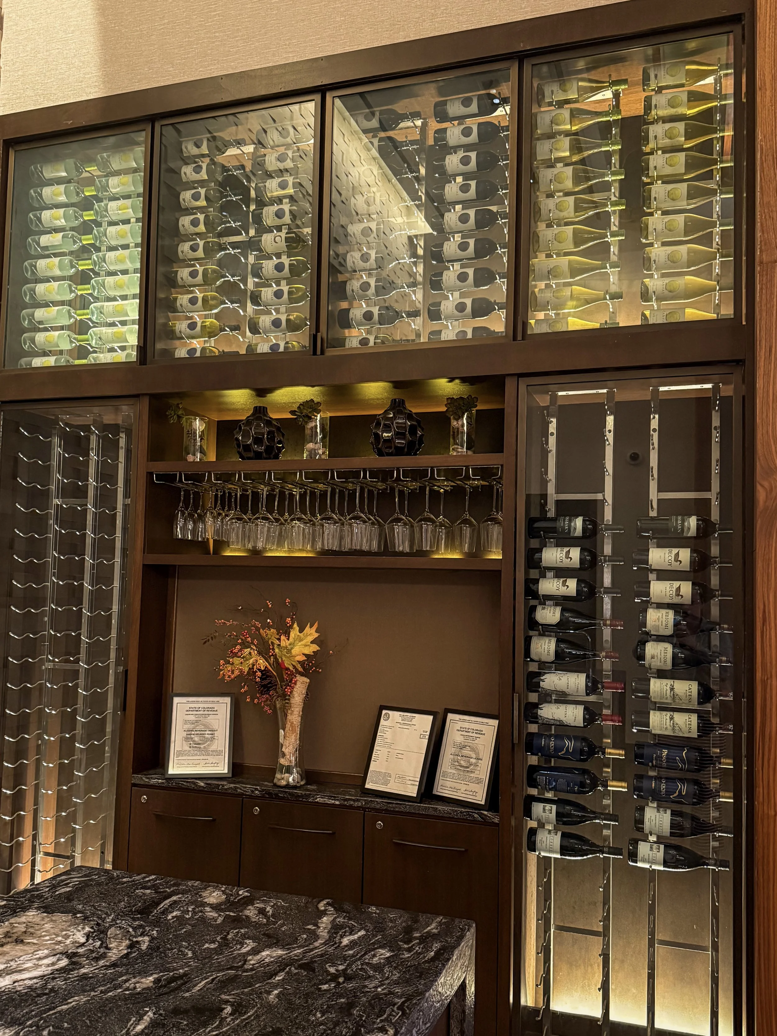 Illuminated wine display featuring an extensive selection of red and white wines