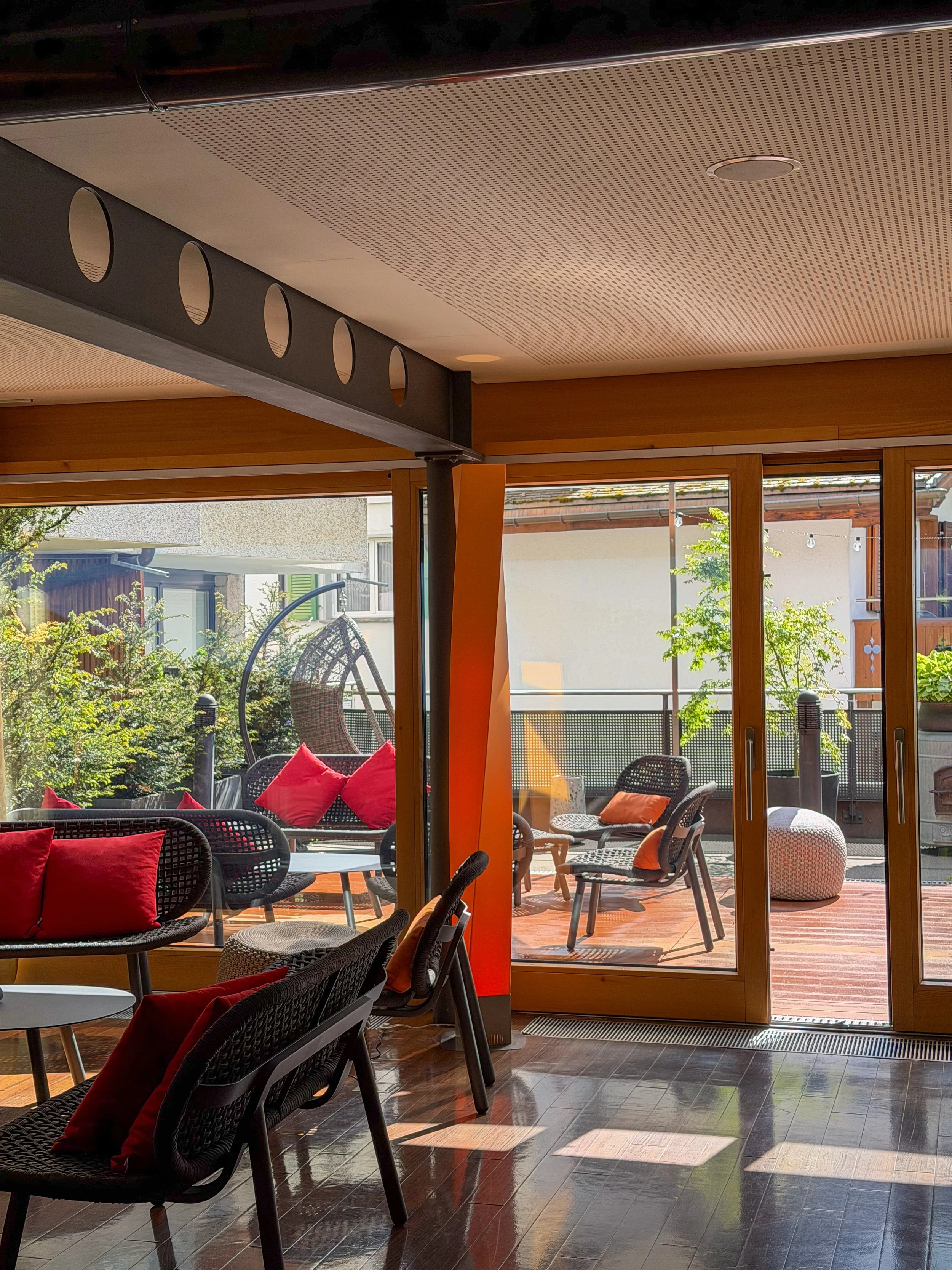Stylish wellness lounge with indoor-outdoor seating, warm natural light and relaxing spa atmosphere at Eiger Mountain & Spa Soul Resort