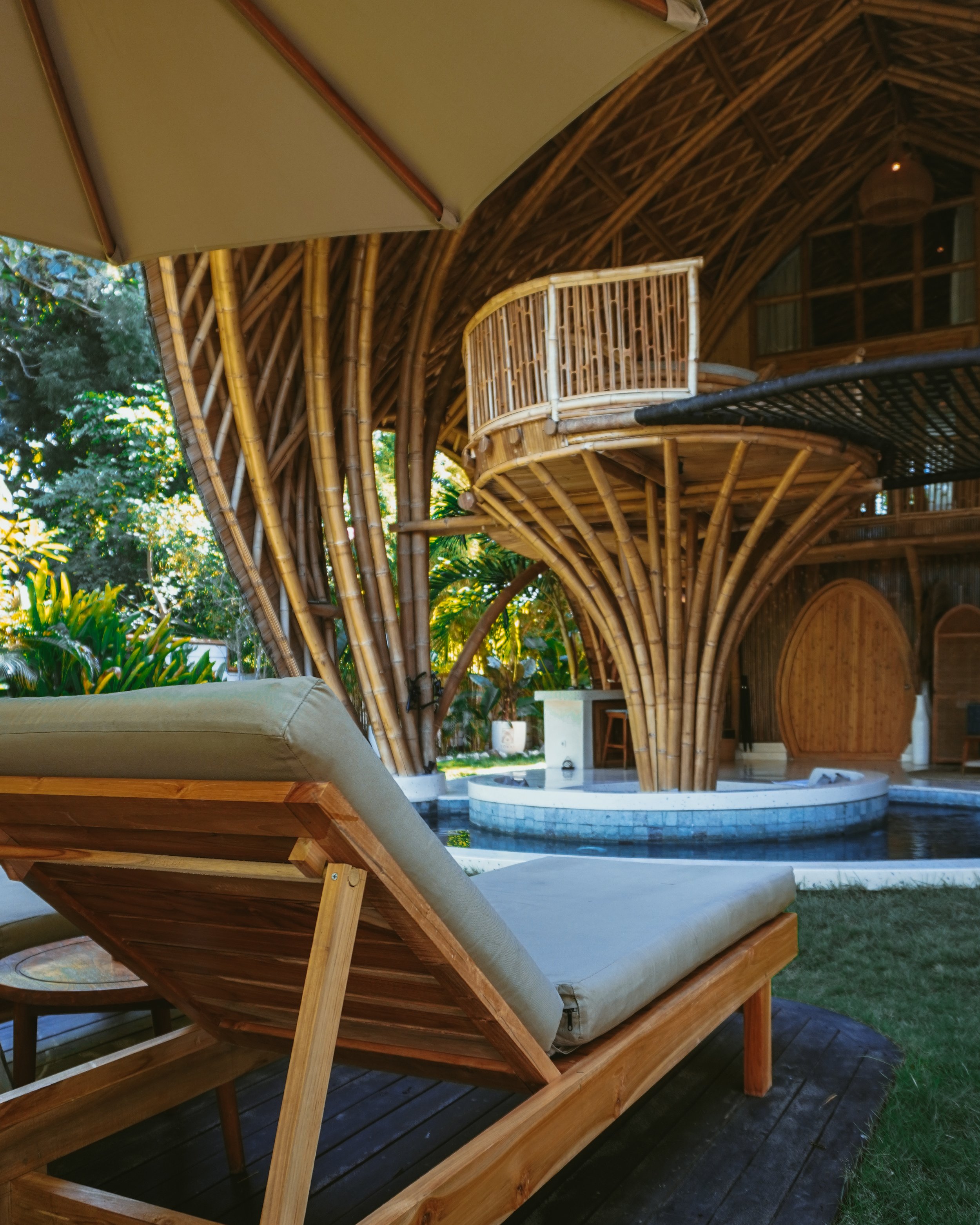 Sunlit bamboo structure with curved architecture and private pool area at Villa Tokay, Indonesia