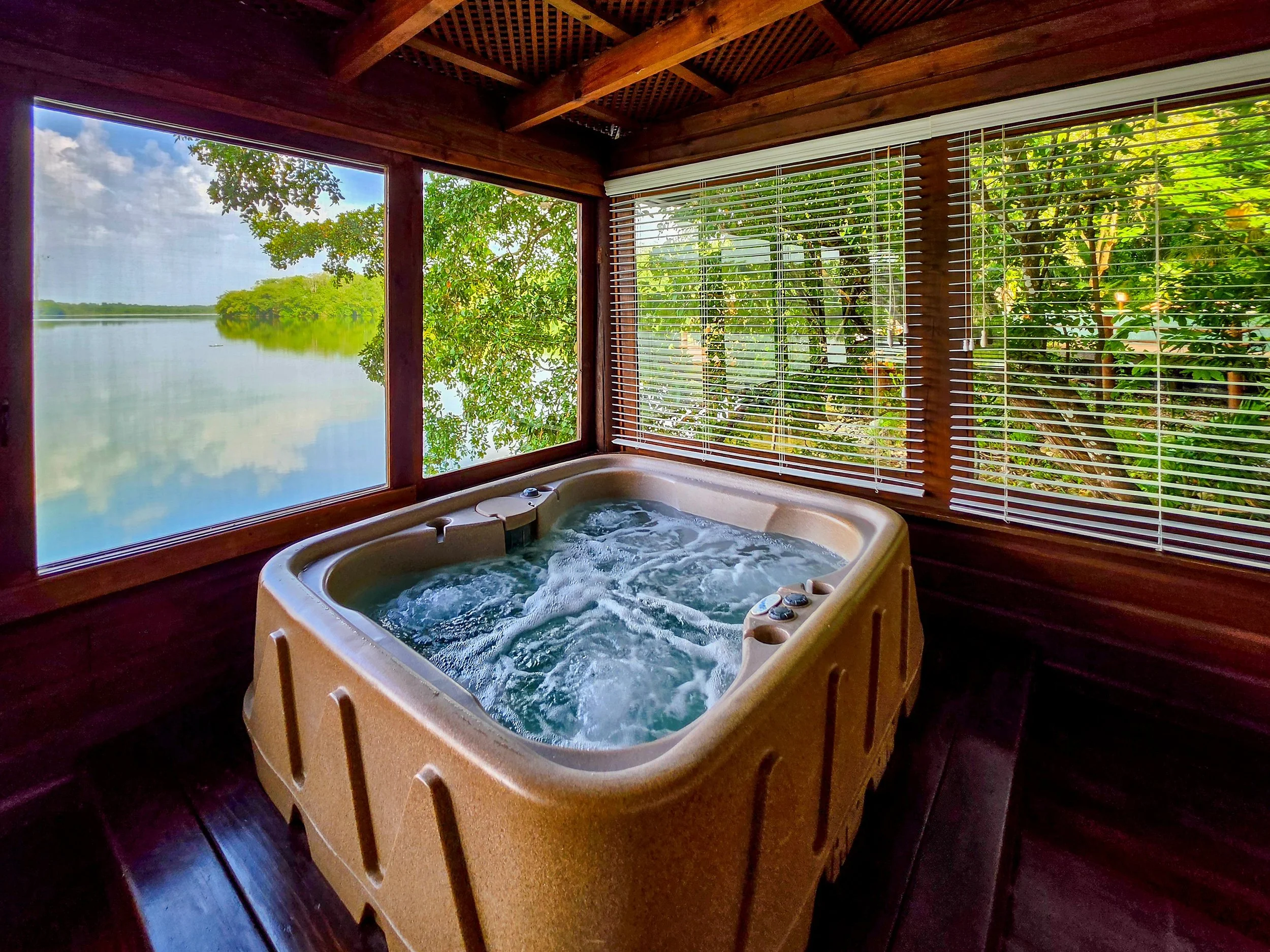 Private indoor jacuzzi overlooking tranquil lagoon and tropical forest