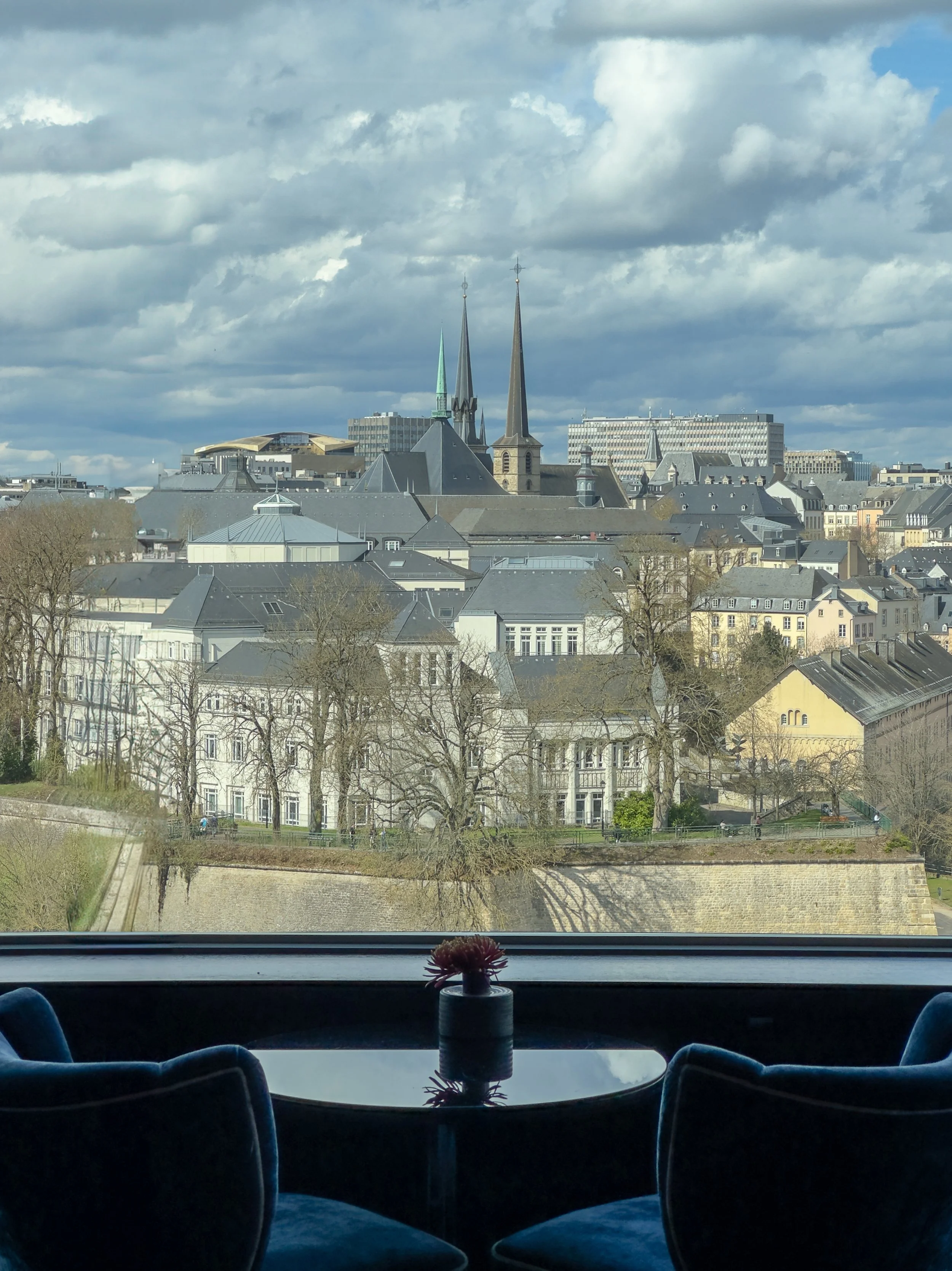 Panoramic lounge overlooking Luxembourg City’s historic skyline through floor-to-ceiling windows