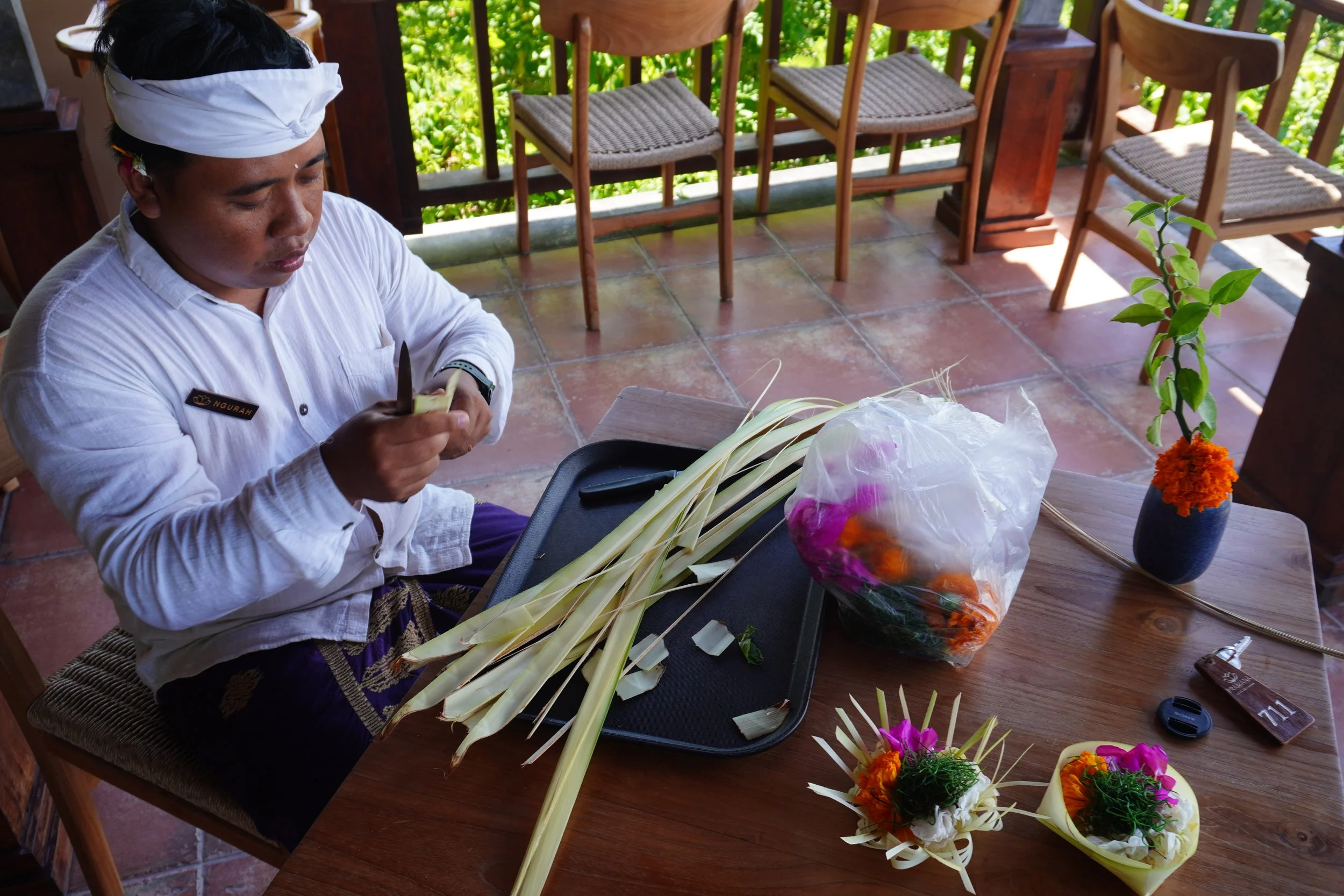 Balinese staff preparing traditional flower offerings during a cultural experience