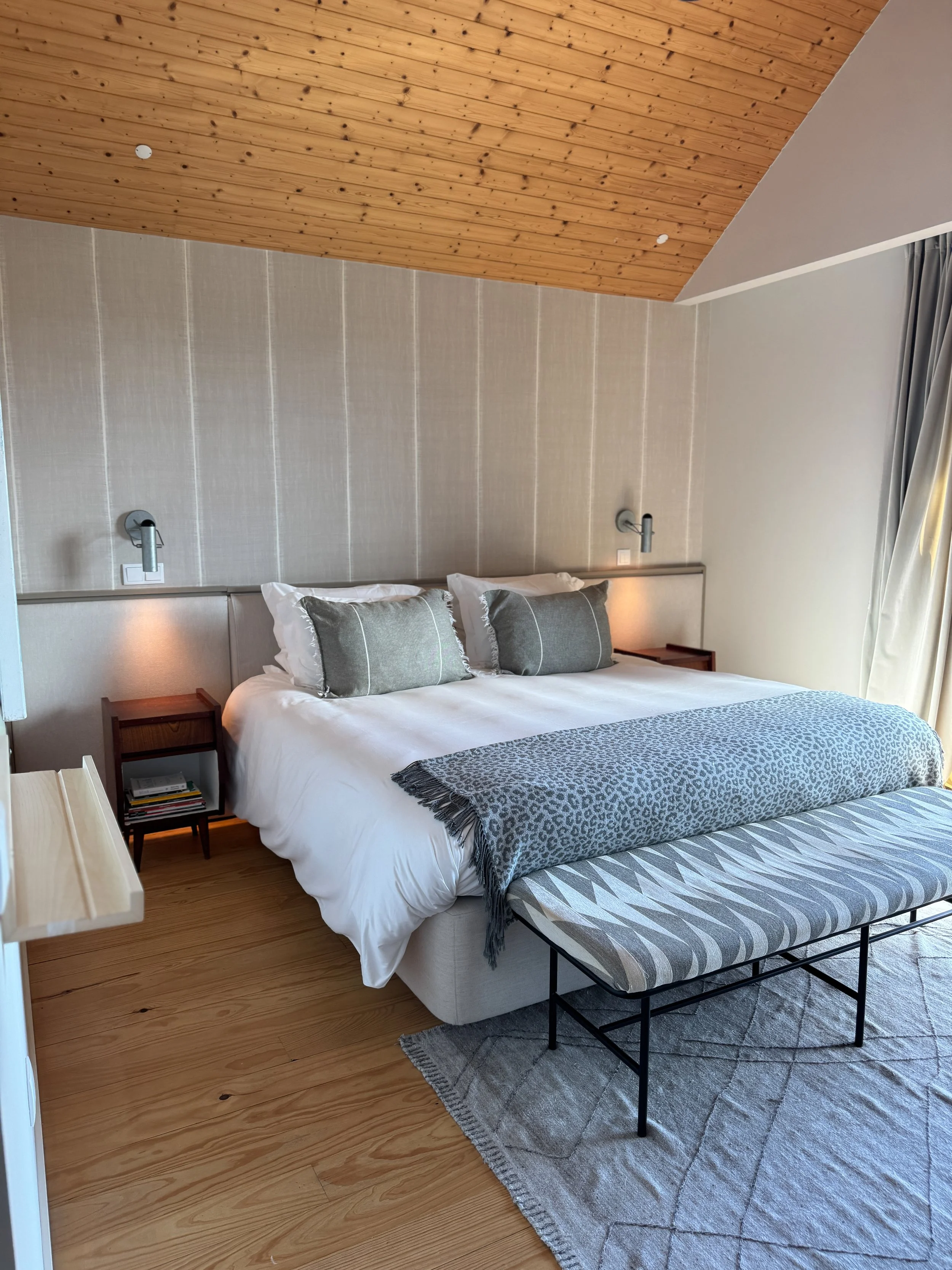 Bright and serene bedroom with wooden ceilings and neutral tones at Dream Guincho in Portugal