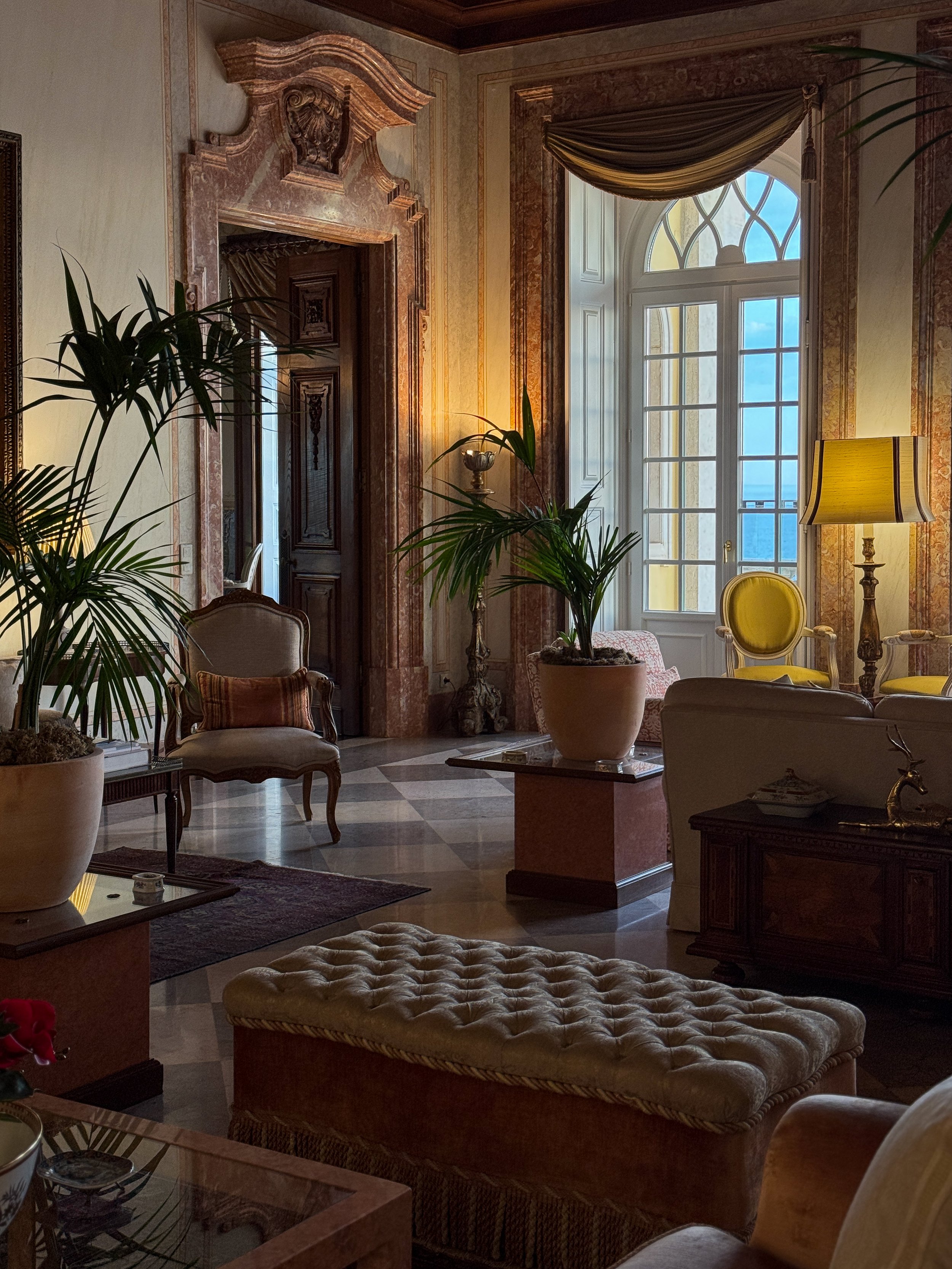 Original marble details, antique furnishings, and ocean views create an elegant lounge