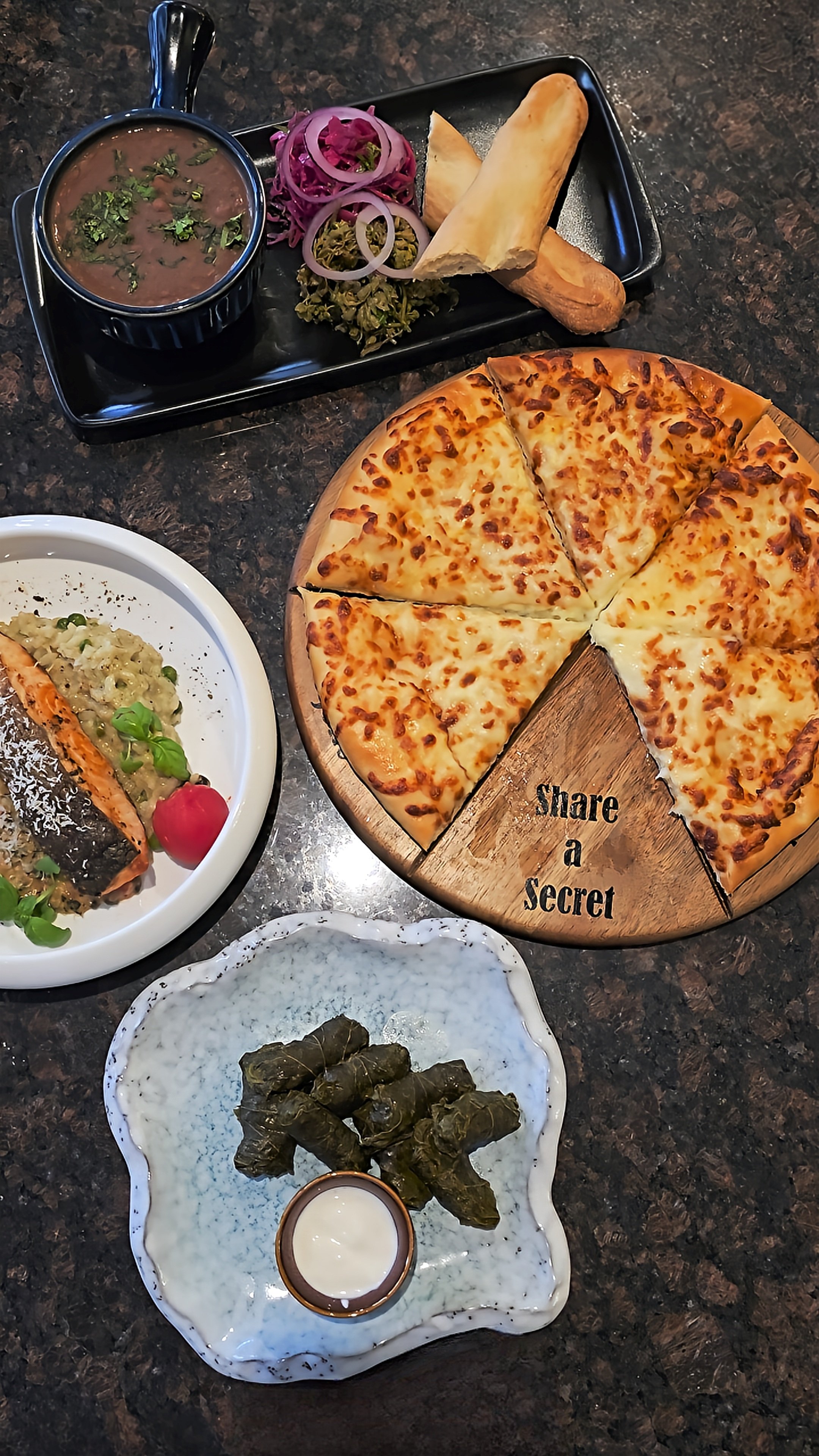 Selection of Georgian-inspired dishes including cheese bread, stuffed vine leaves, and traditional sides