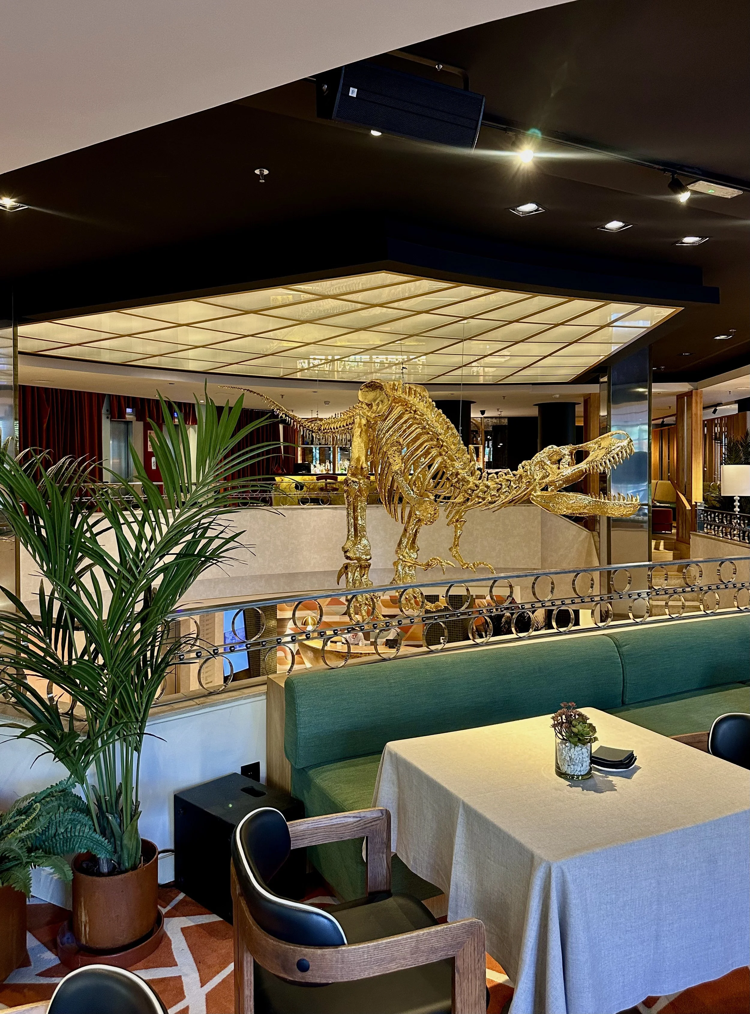 Golden dinosaur sculpture creating a striking centerpiece inside the restaurant
