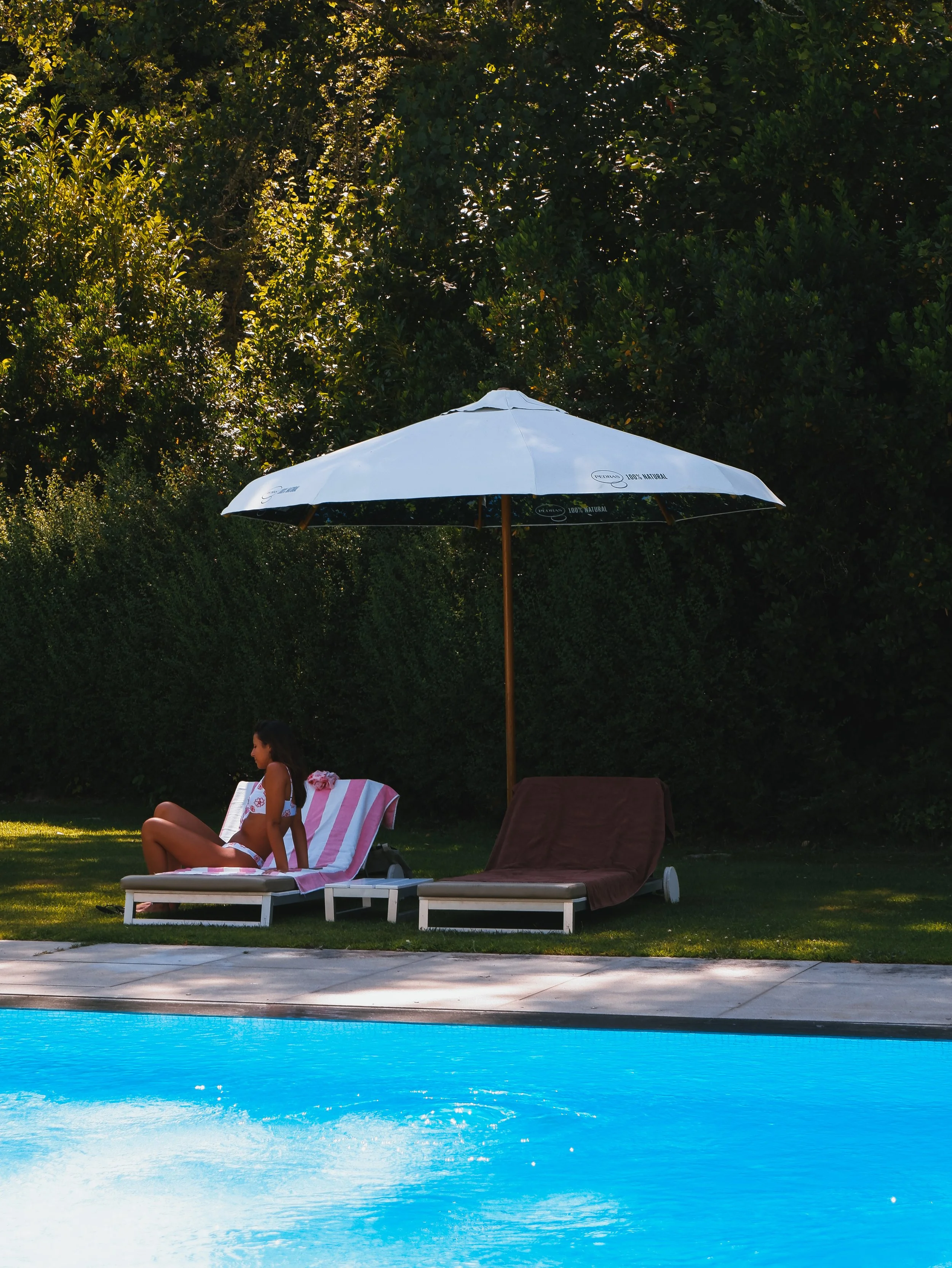 Quiet poolside lounge area surrounded by nature for relaxing summer afternoons