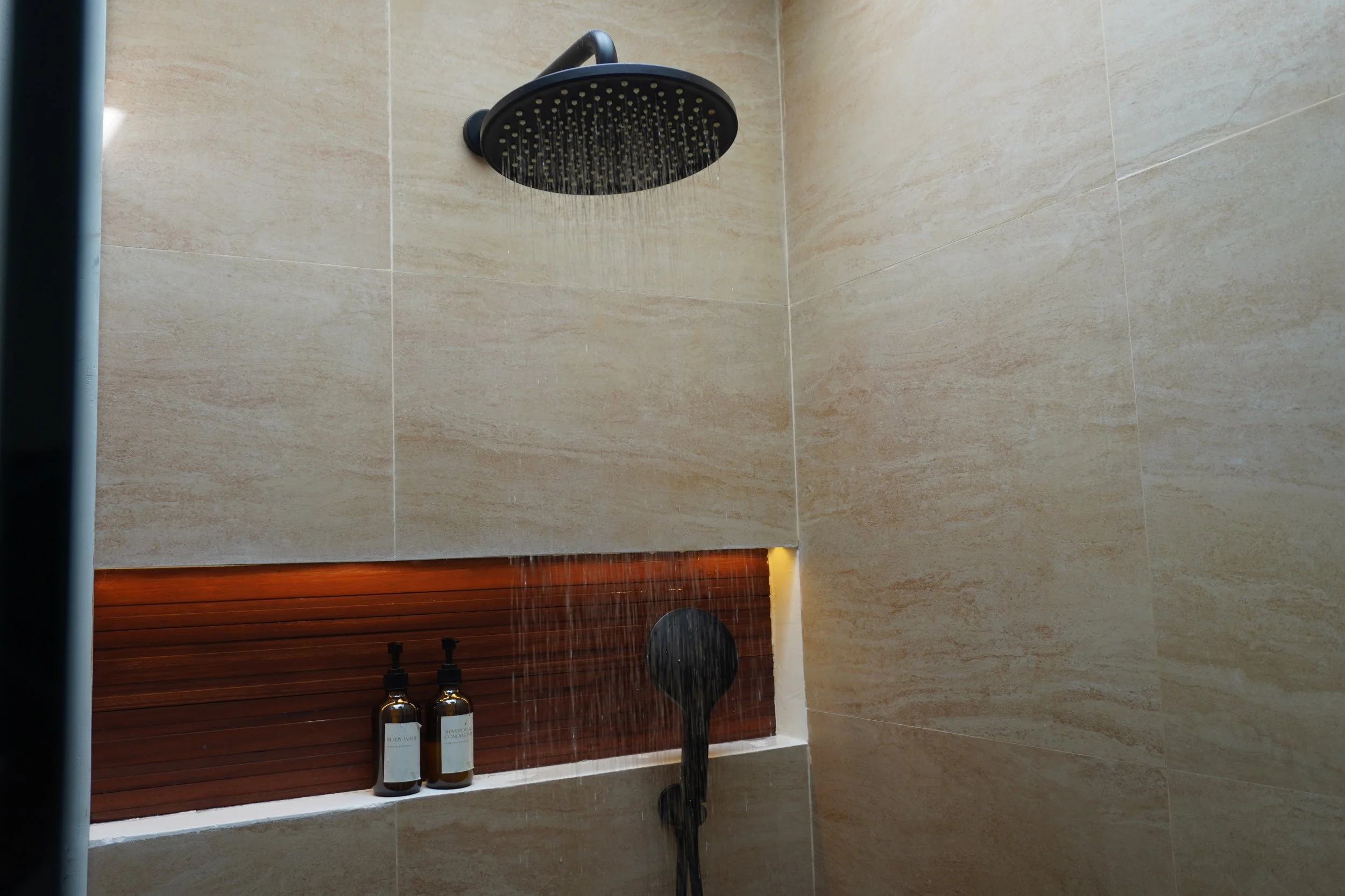 Rainfall shower with natural stone finishes and premium bath amenities