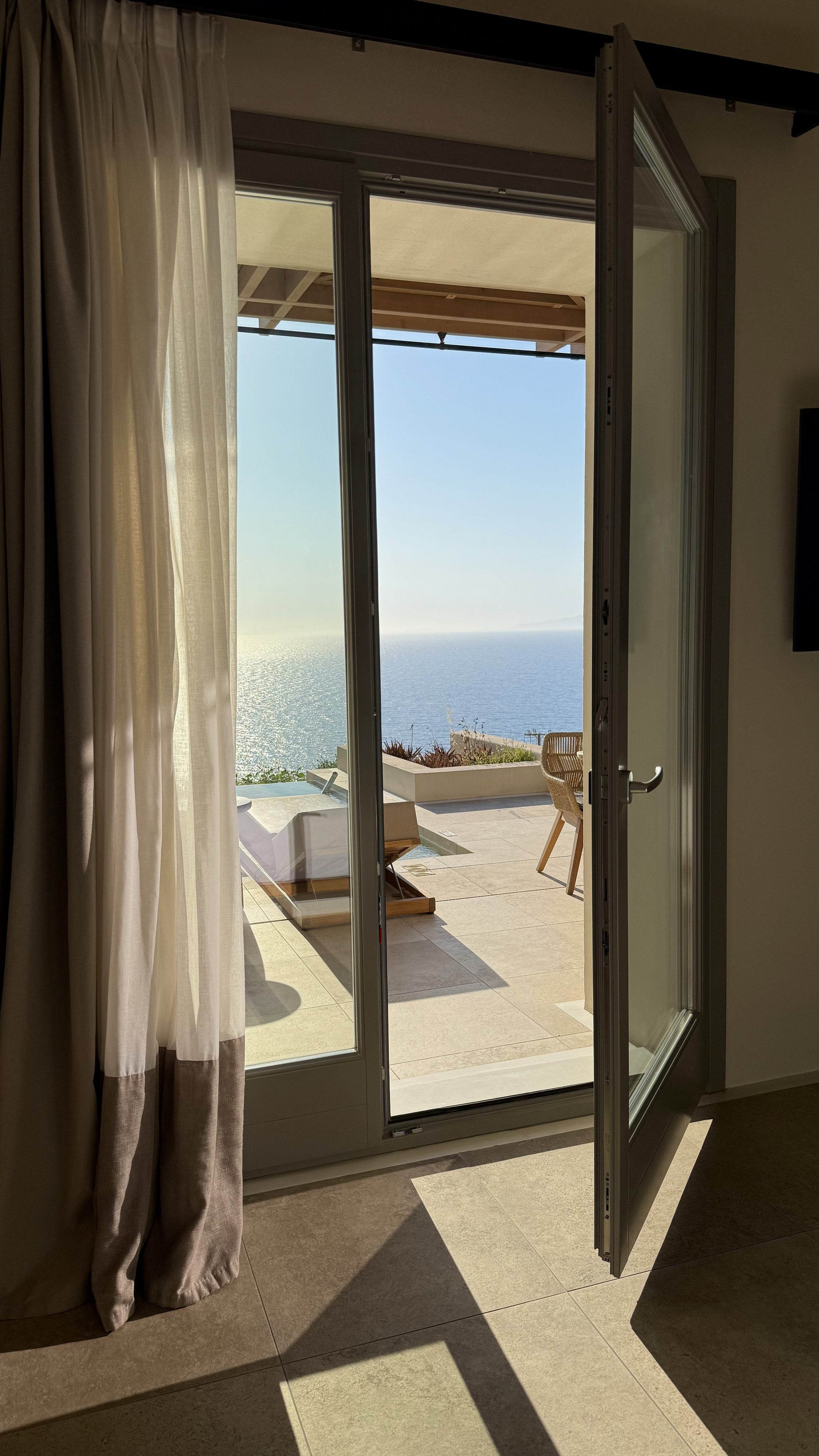 Elegant suite opening onto a private terrace with panoramic sea views and abundant natural light