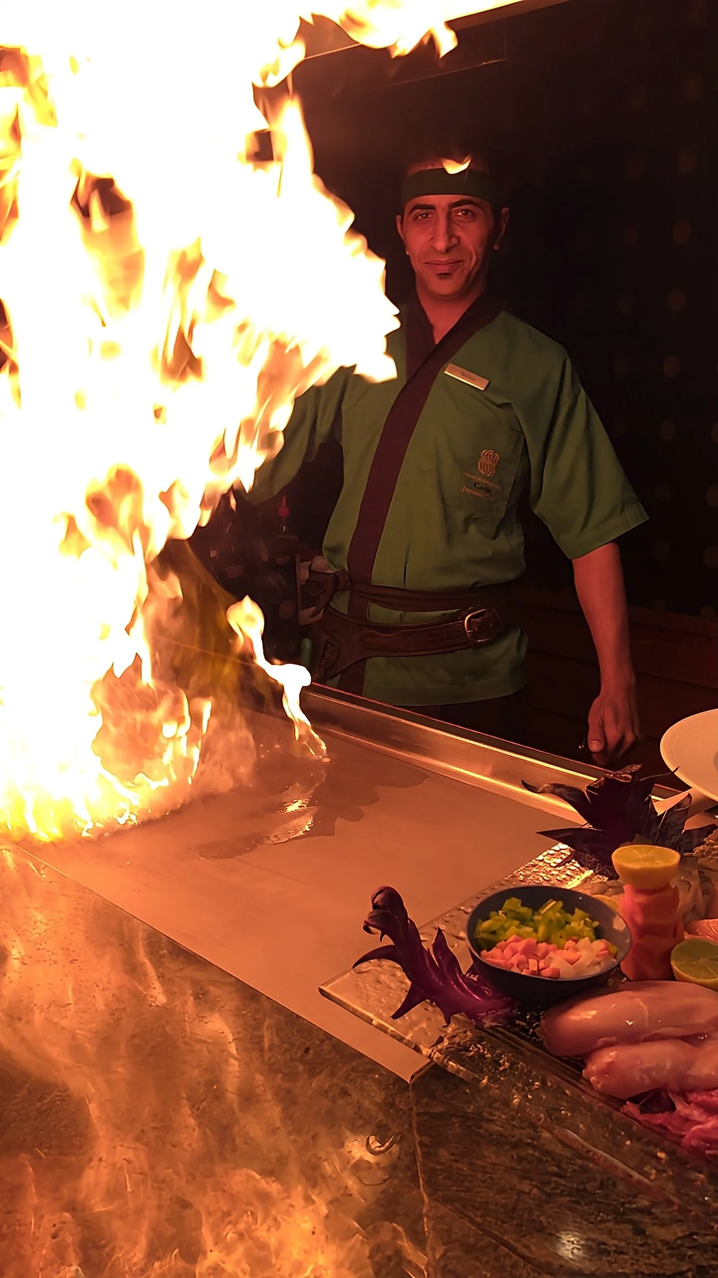 Teppanyaki chef performing live cooking with dramatic flames in an immersive restaurant setting, Sonesta St. George Hotel Luxor.