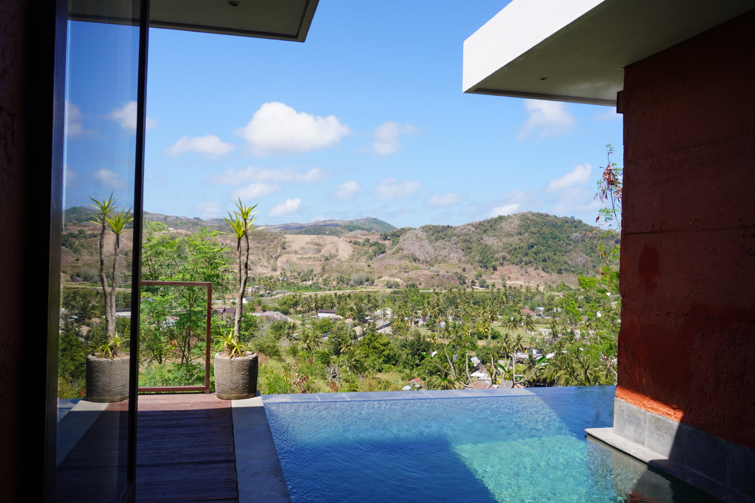 Private plunge pool overlooking rolling hills and tropical landscape