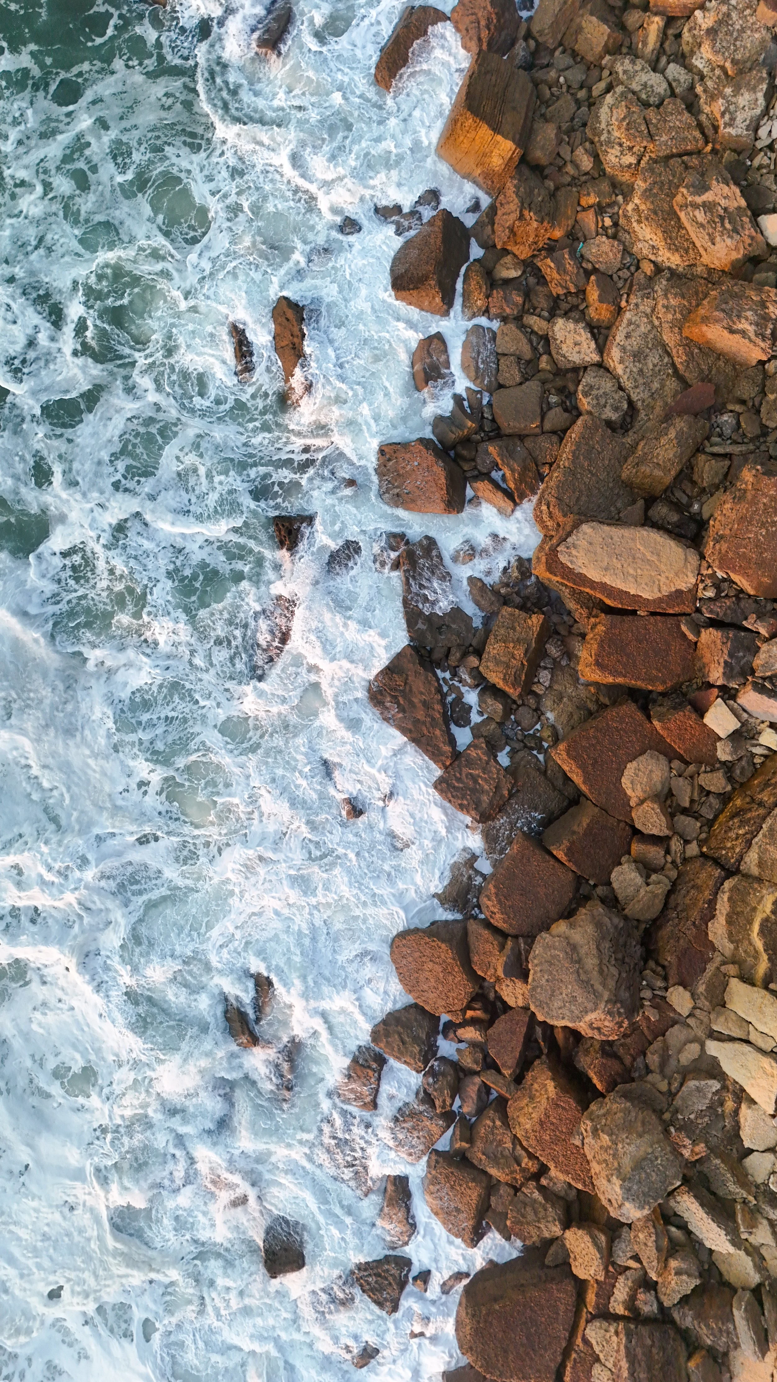 Aerial view of Atlantic waves crashing against the rocky shoreline beside Arribas Hotel in Sintra