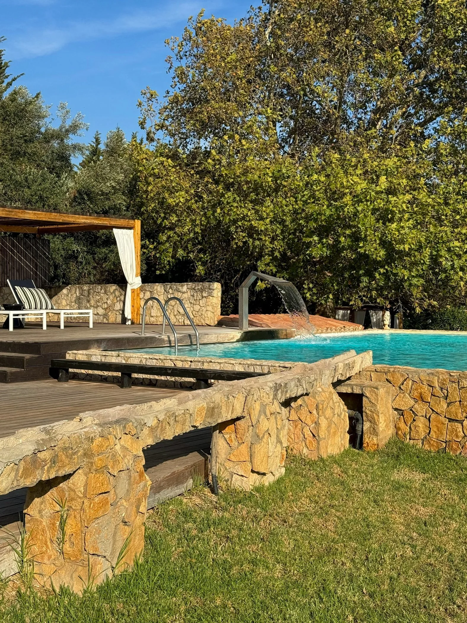 Outdoor swimming pool surrounded by gardens and relaxing sun loungers at Vila Valverde