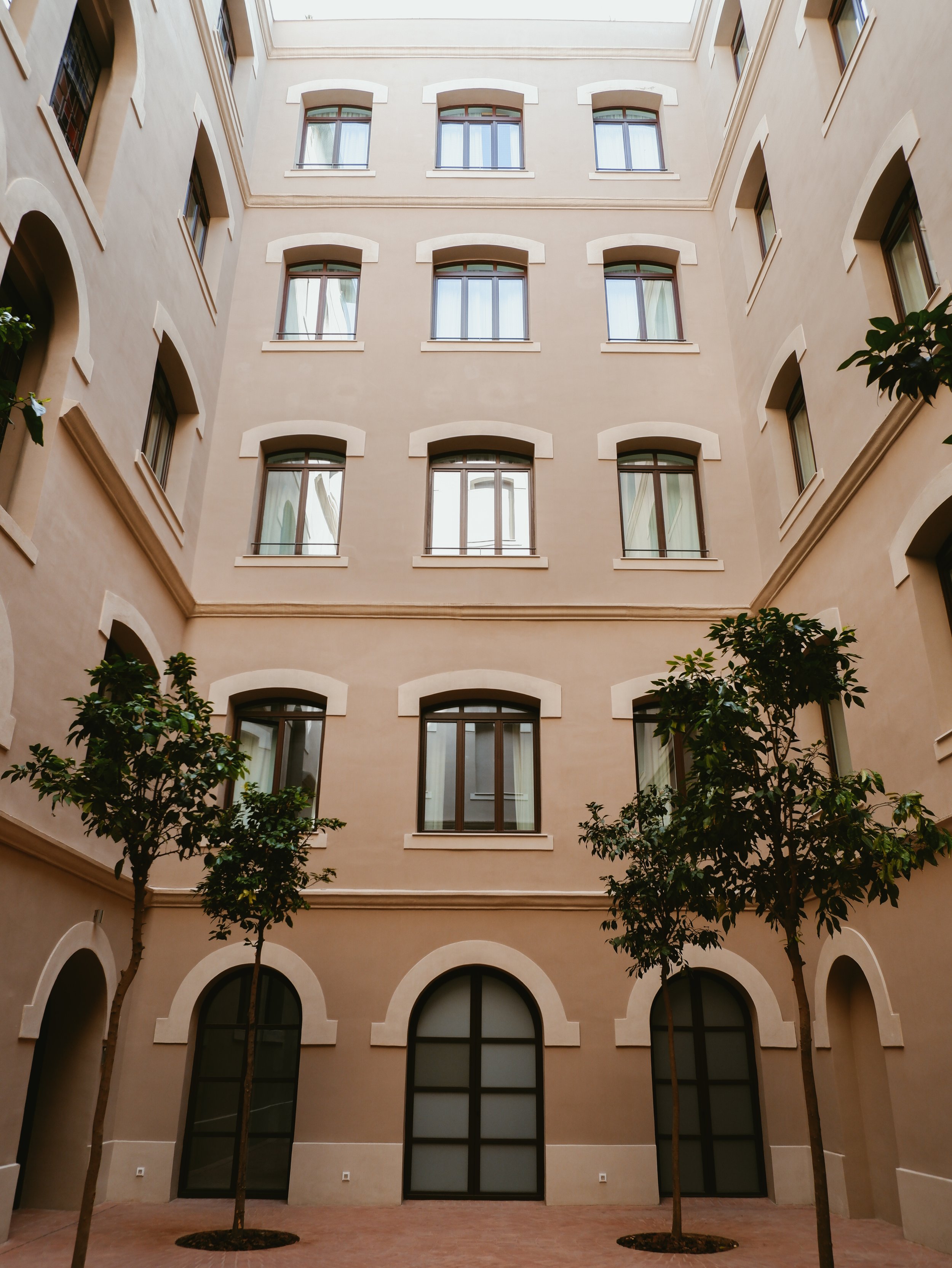 Peaceful interior courtyard framed by elegant architecture and mature trees