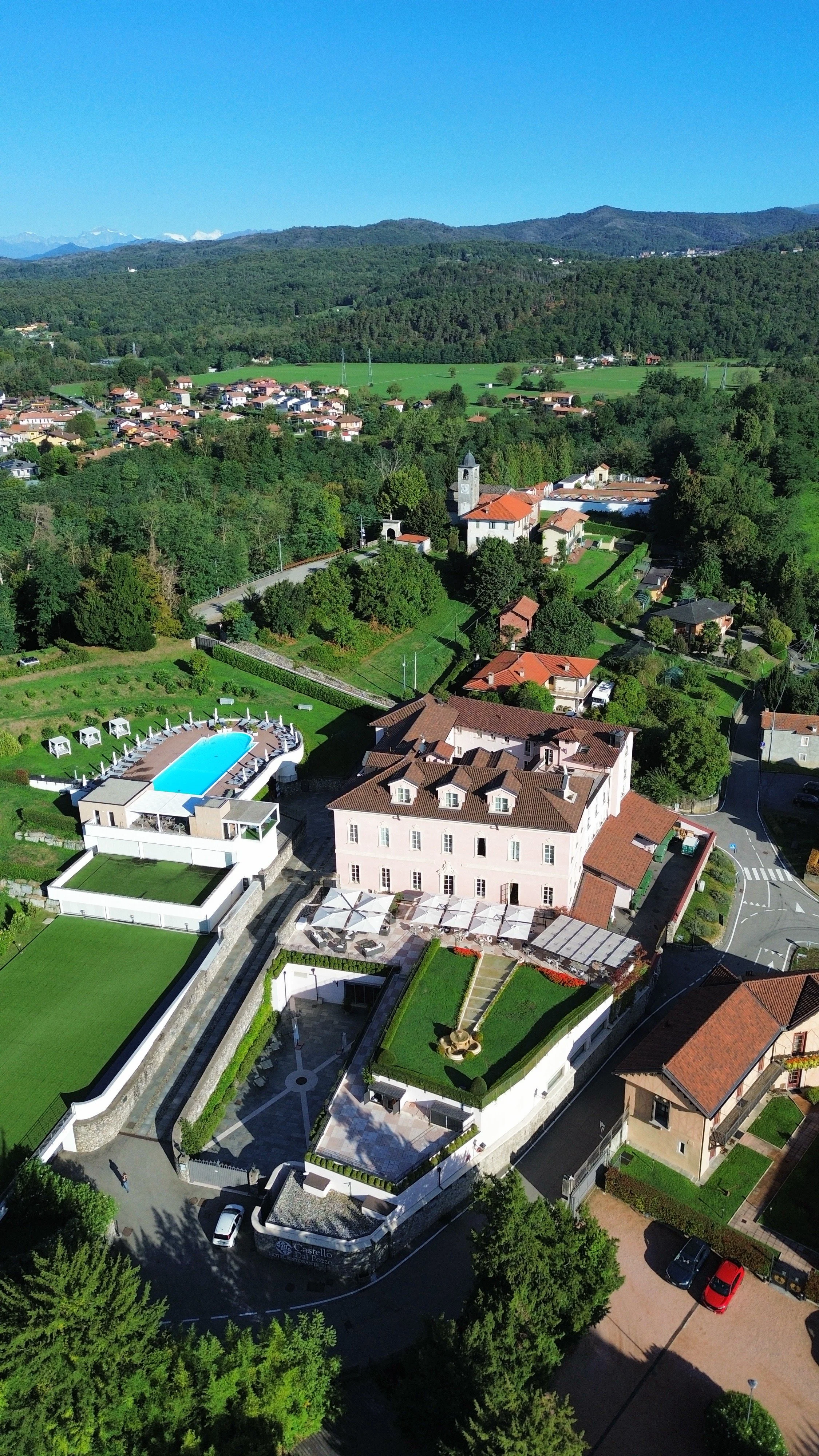 Aerial view of the historic estate with gardens, outdoor pool, and surrounding Piedmont countryside