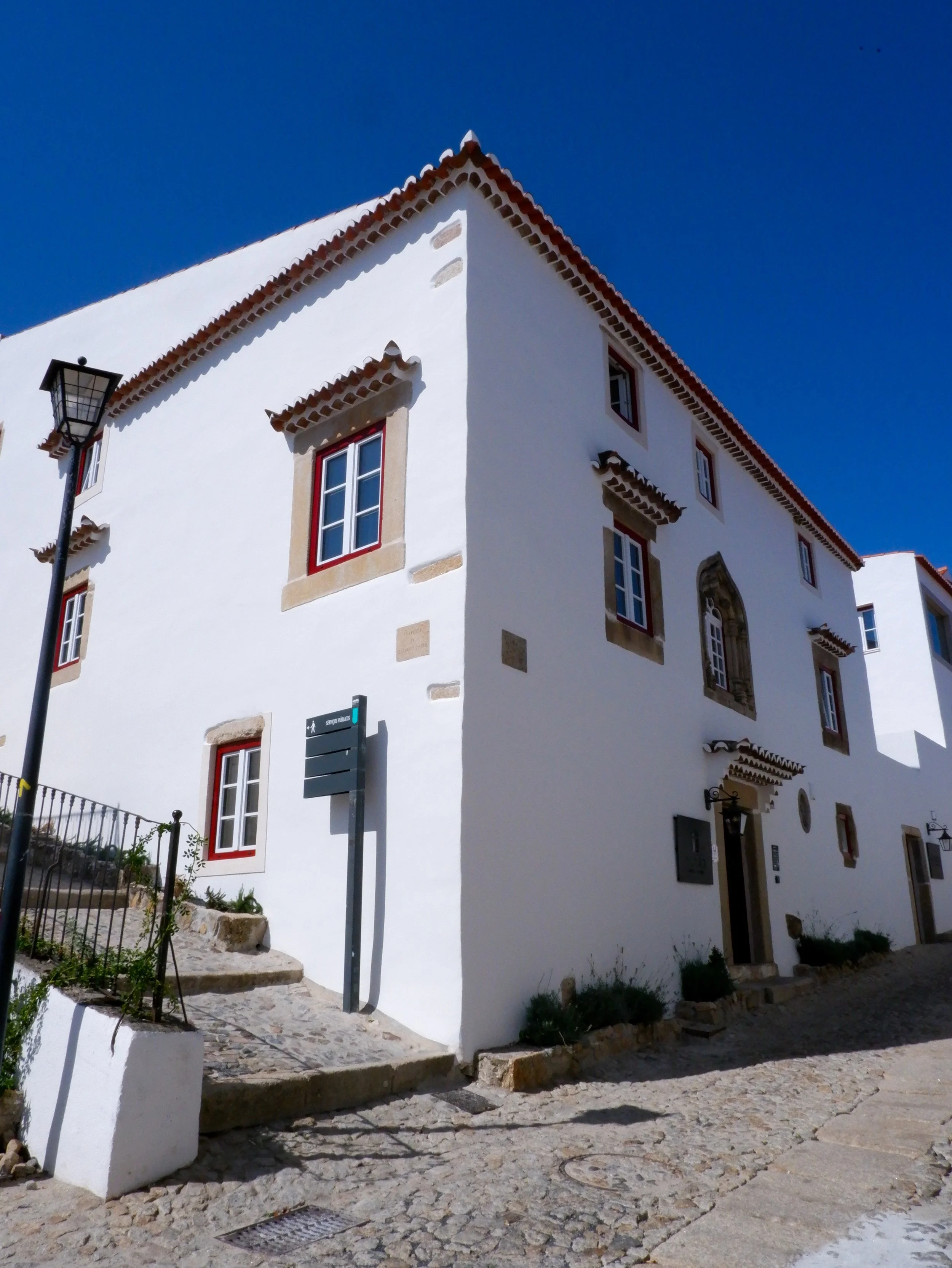 Traditional whitewashed hotel exterior with stone-framed windows on a cobbled street in historic Marvão