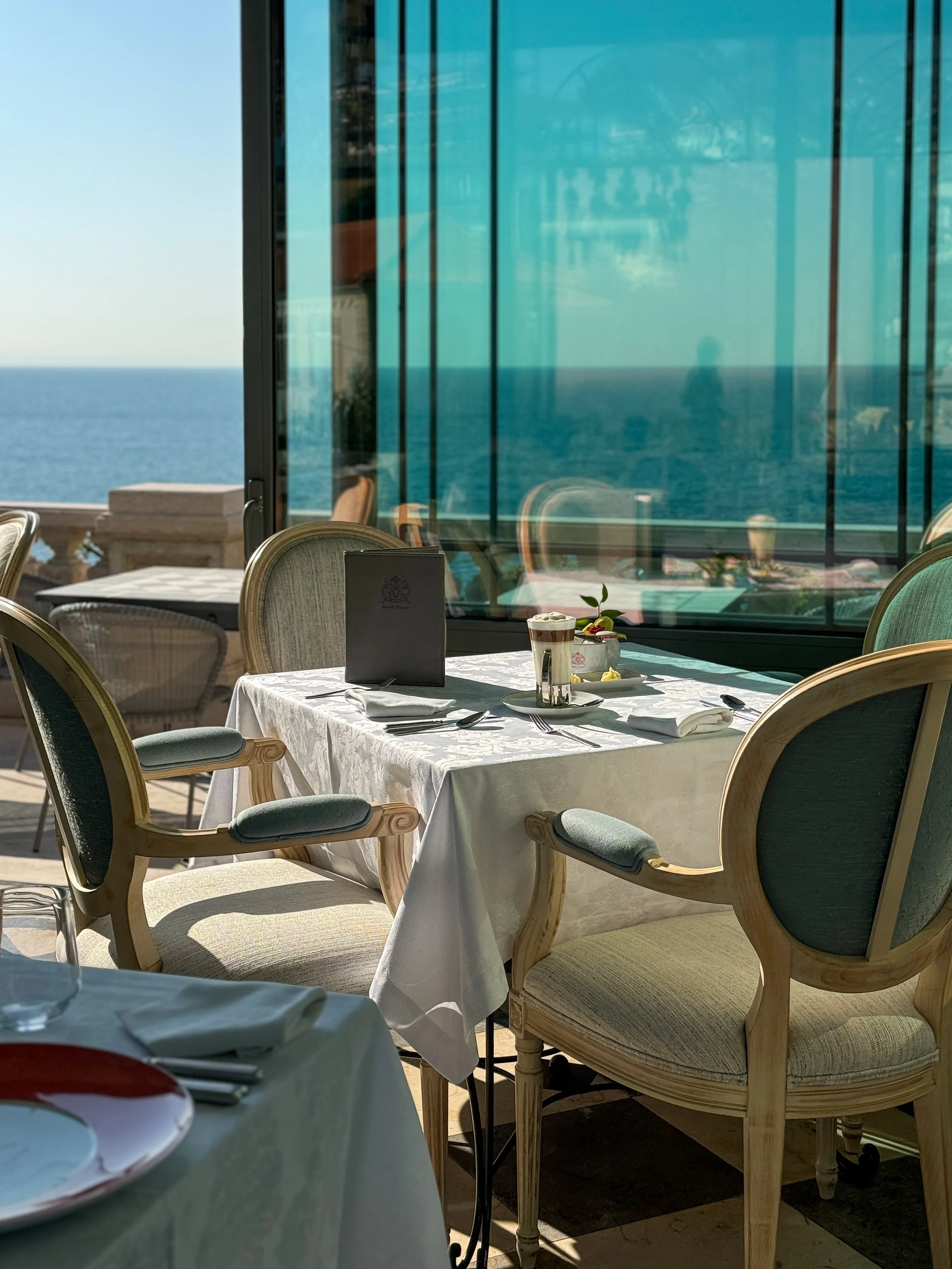 A sunlit table pairs refined dining with uninterrupted views across the Atlantic Ocean